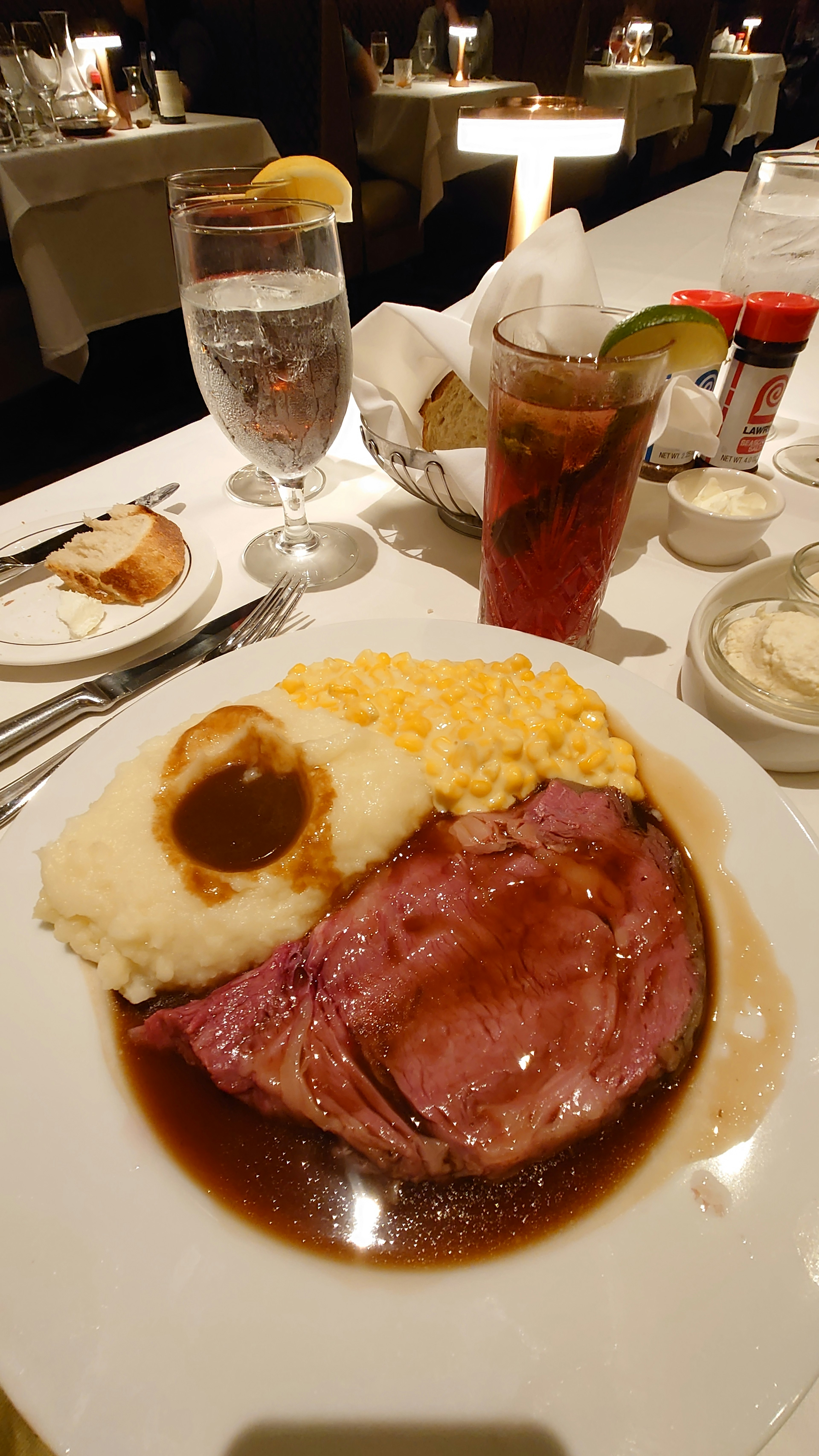 餐盘上有烤牛肉、土豆泥和玉米的精致餐饮场景