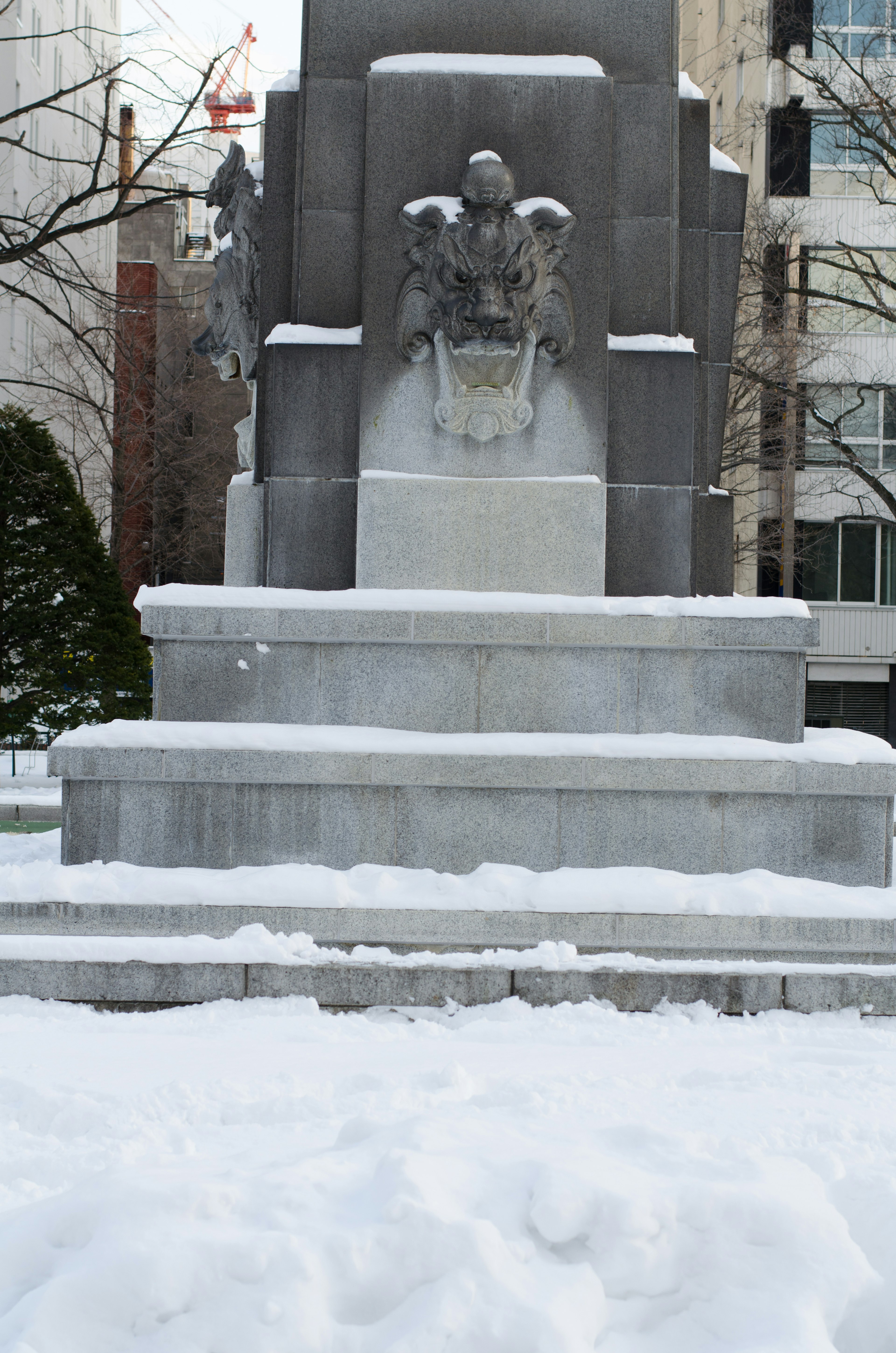 Skulptur an der Basis eines mit Schnee bedeckten Denkmals