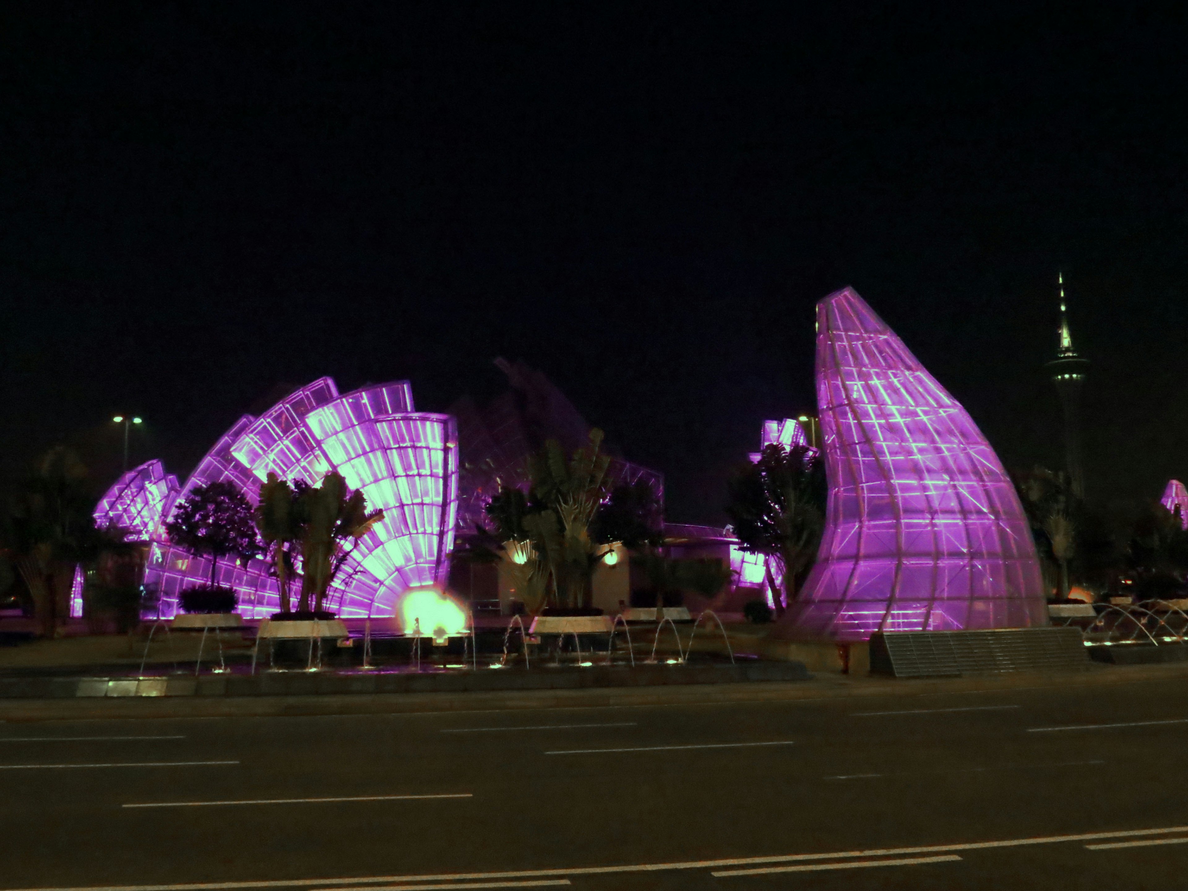 Modern architectural structures illuminated in purple at night