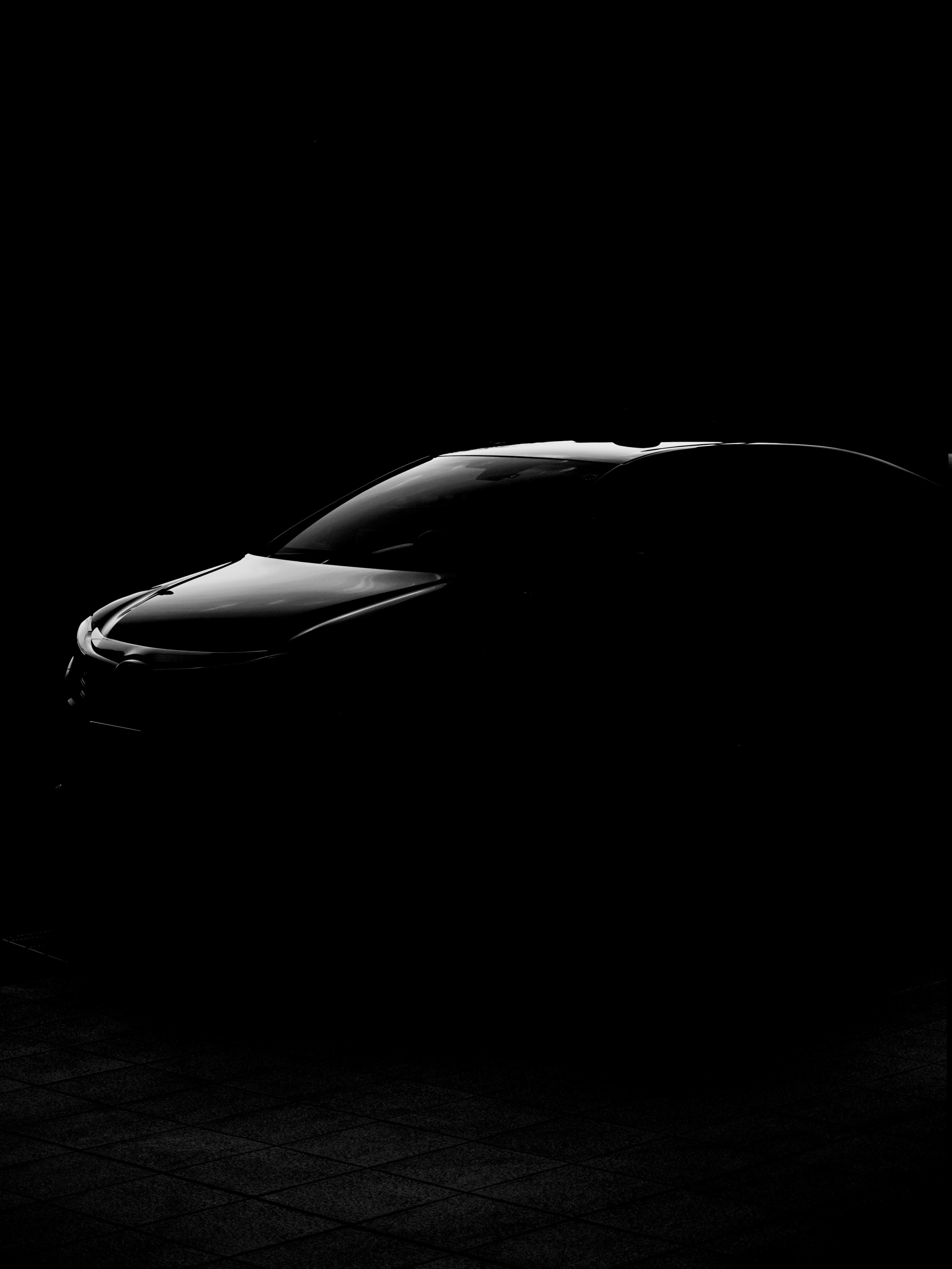 Silhouette of a black car illuminated in low light