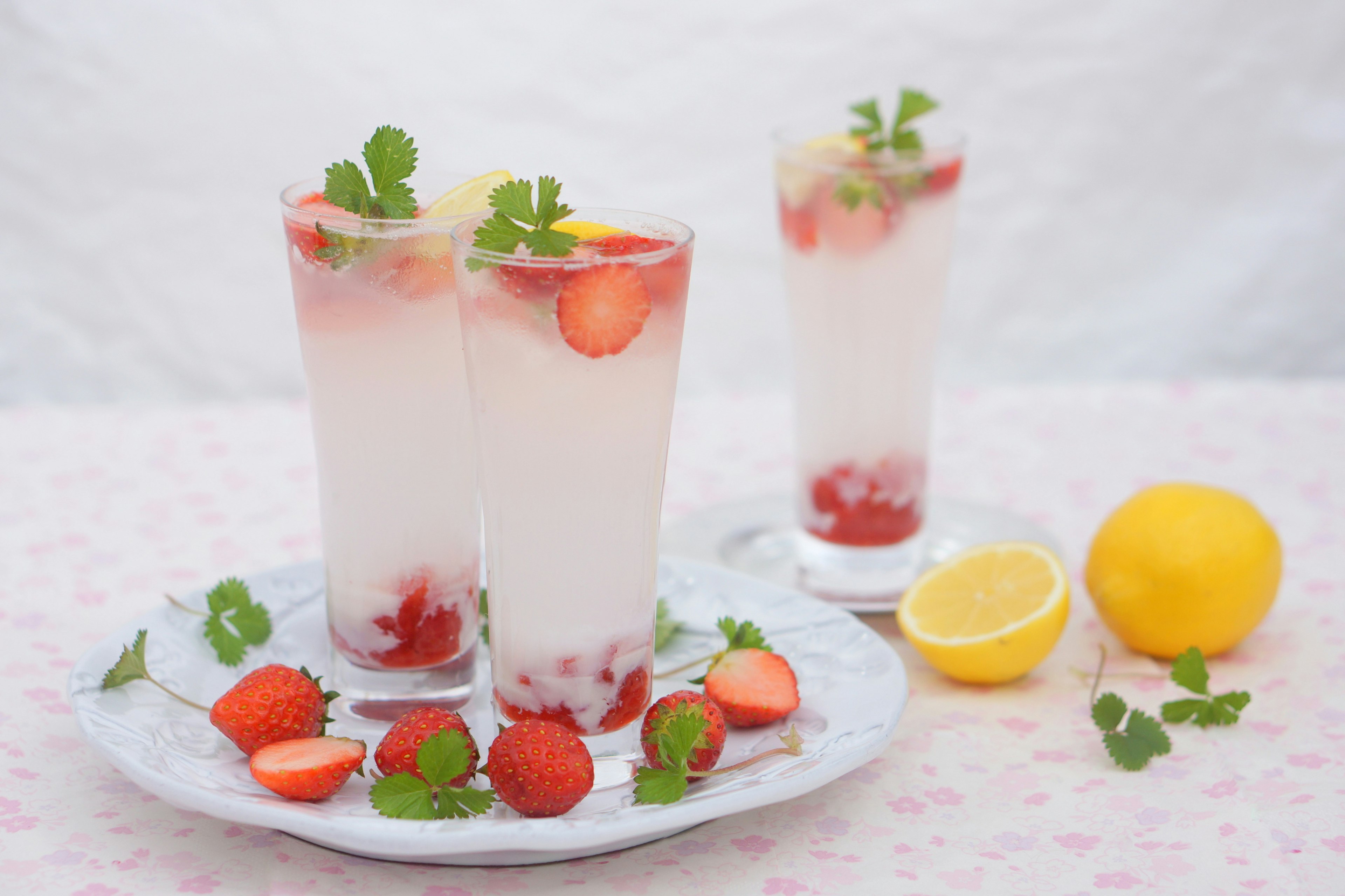 Glasses of strawberry and lemon drinks garnished with mint