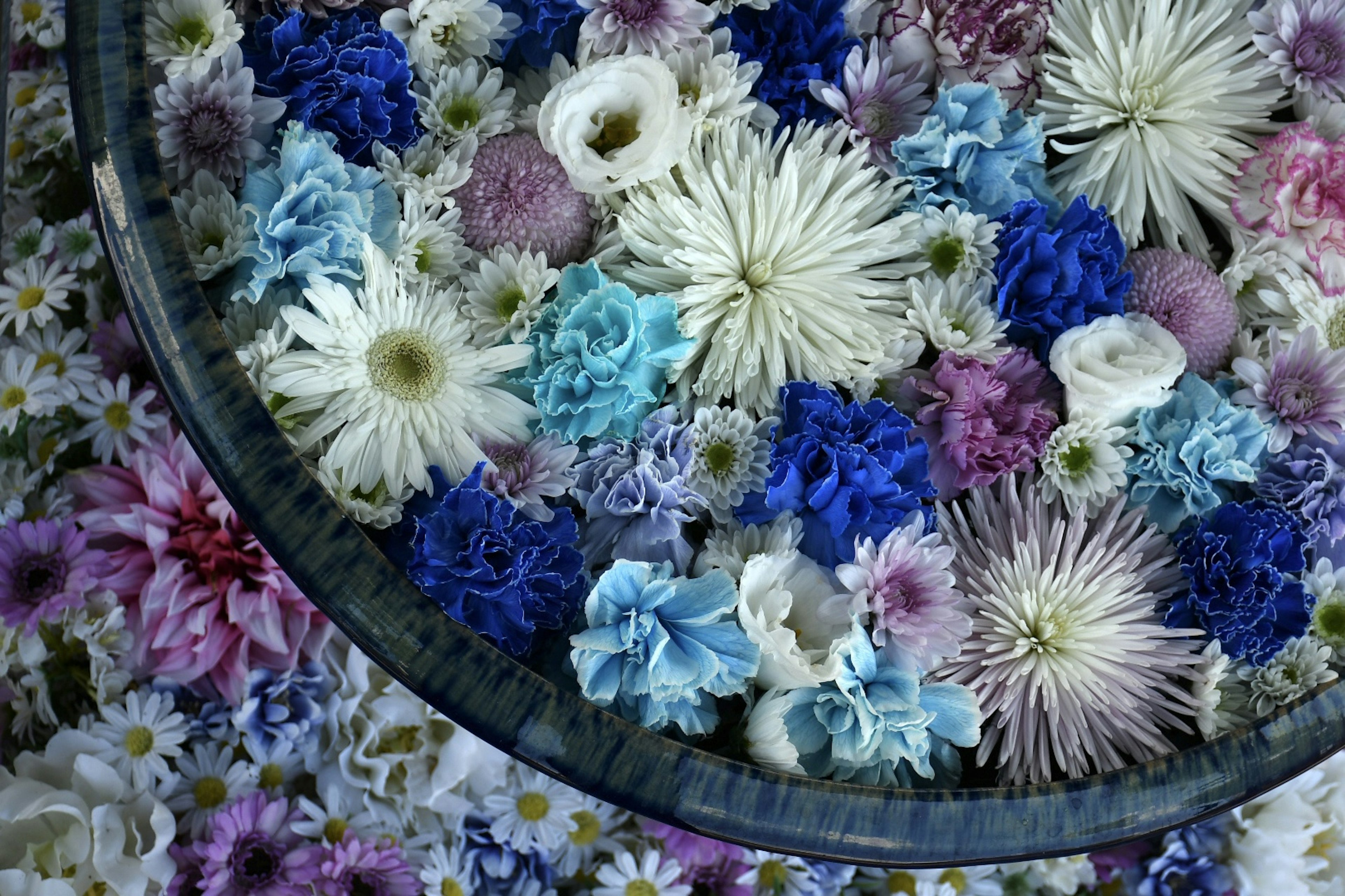 A bowl filled with vibrant flowers in various colors