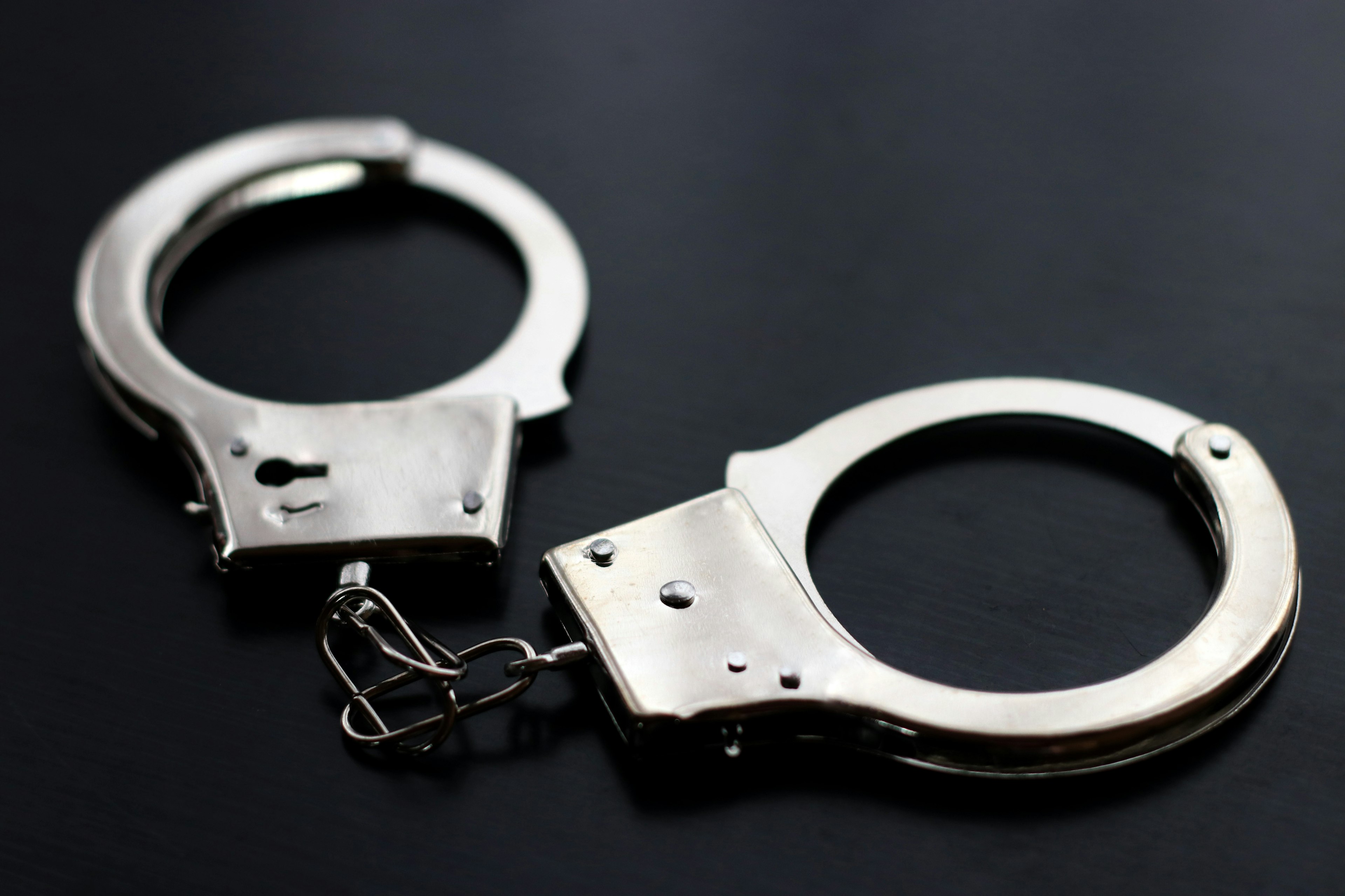 Metal handcuffs placed on a black background