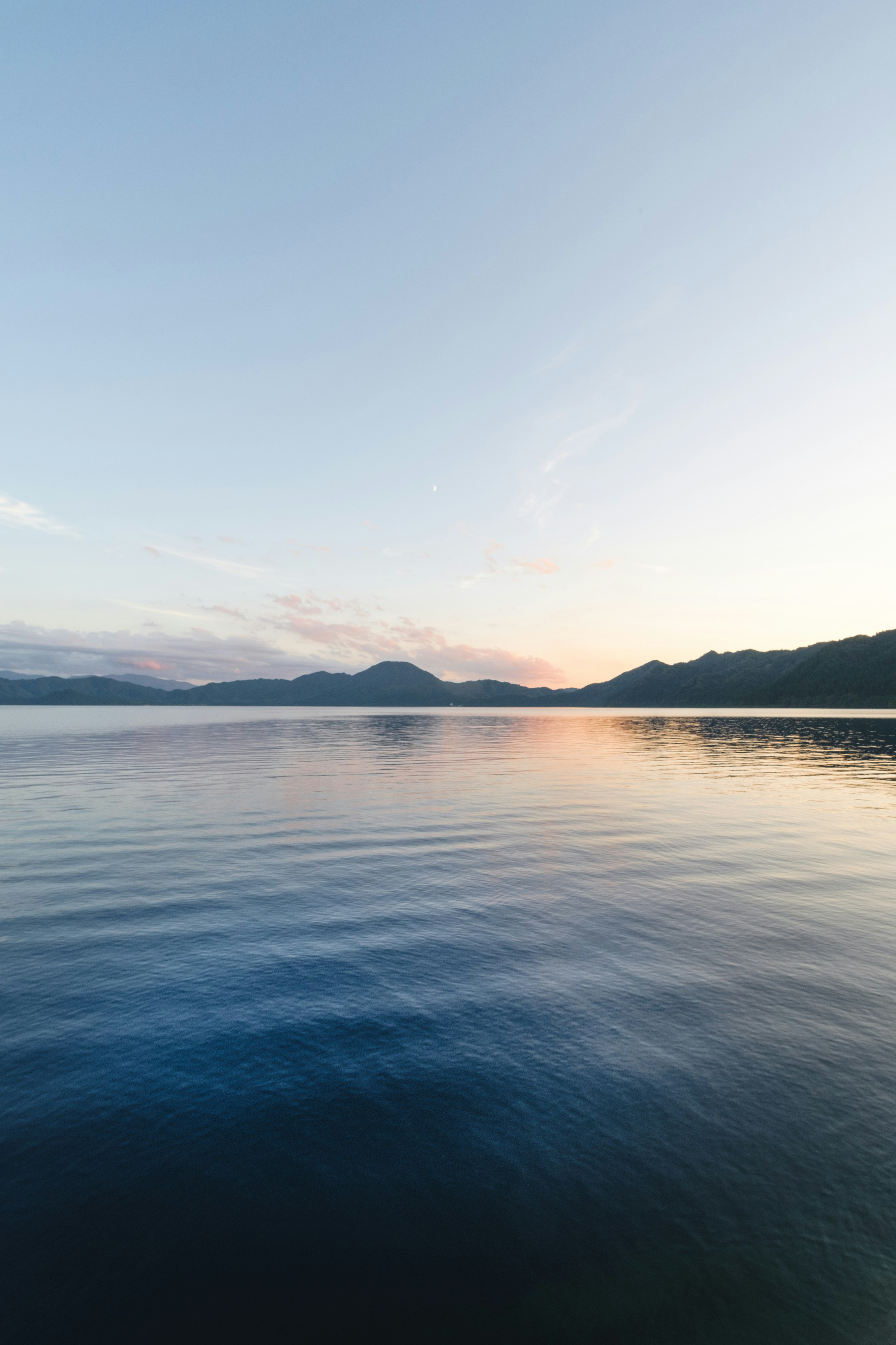 Serene lake reflecting surrounding mountains under a clear sky