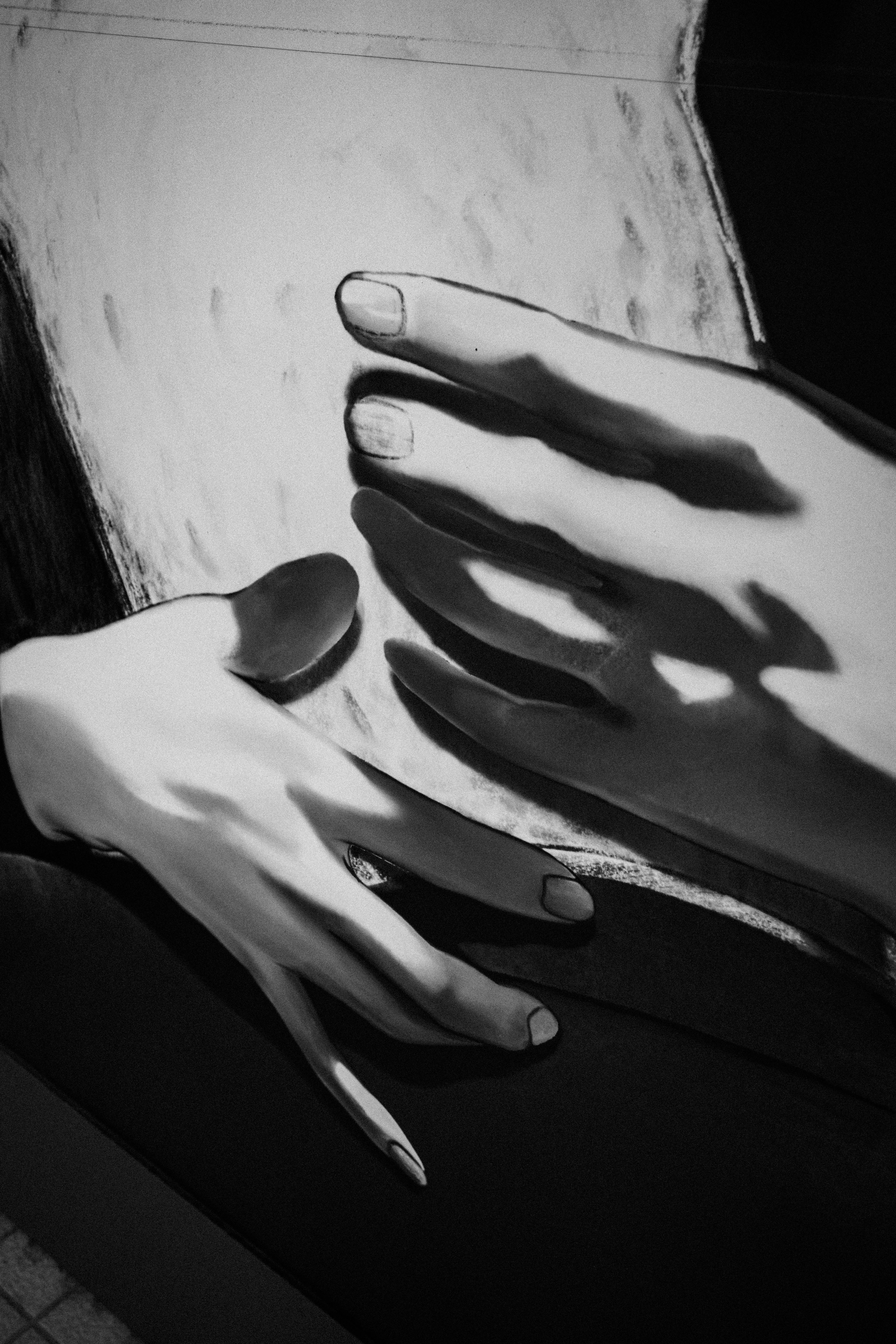 Black and white artistic depiction of hands and shadows