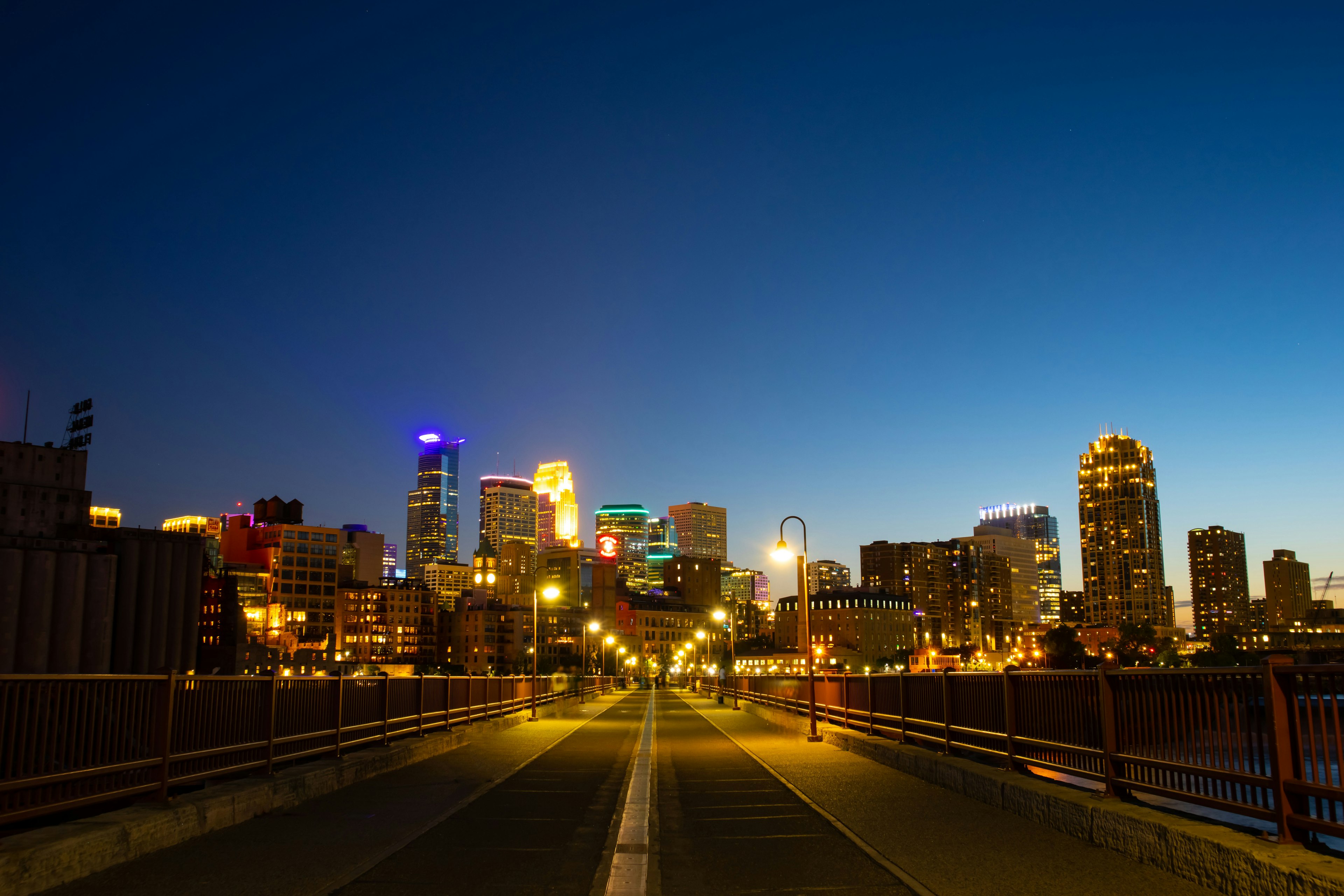 Garis langit Minneapolis saat senja dengan jembatan di latar depan