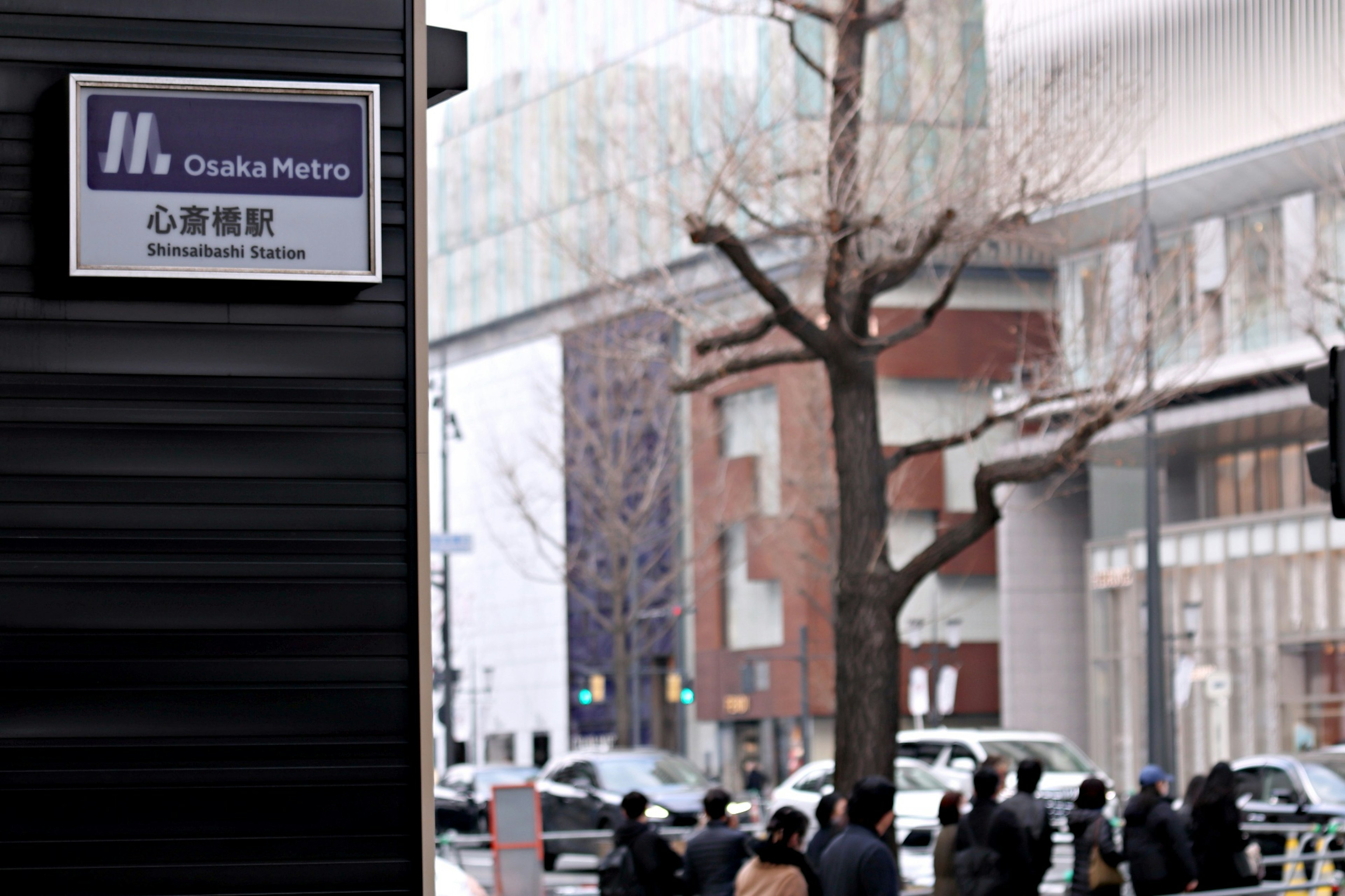 Osaka Metro Shinsaibashi Station sign with pedestrians