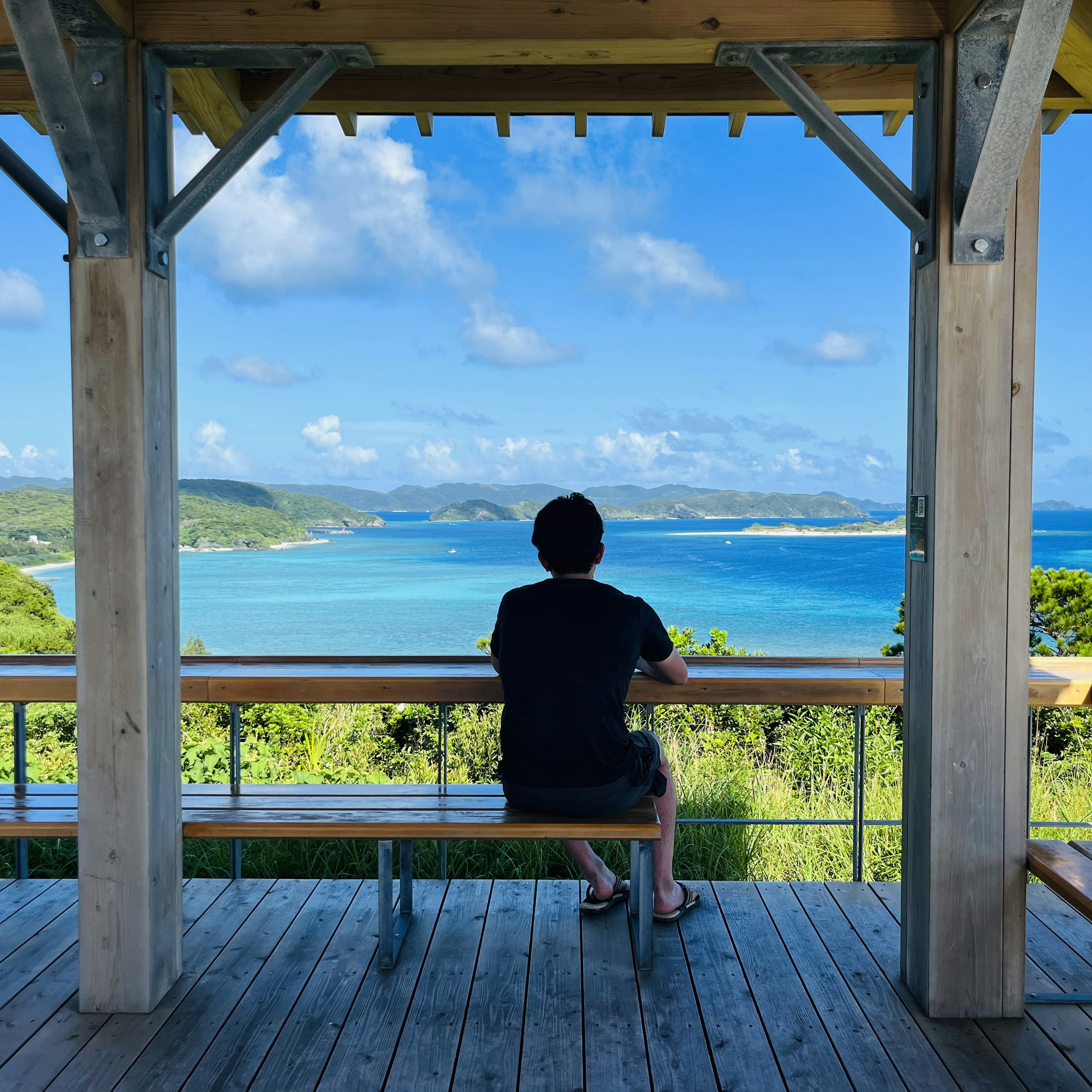 海を見つめる男性がいる展望台の風景