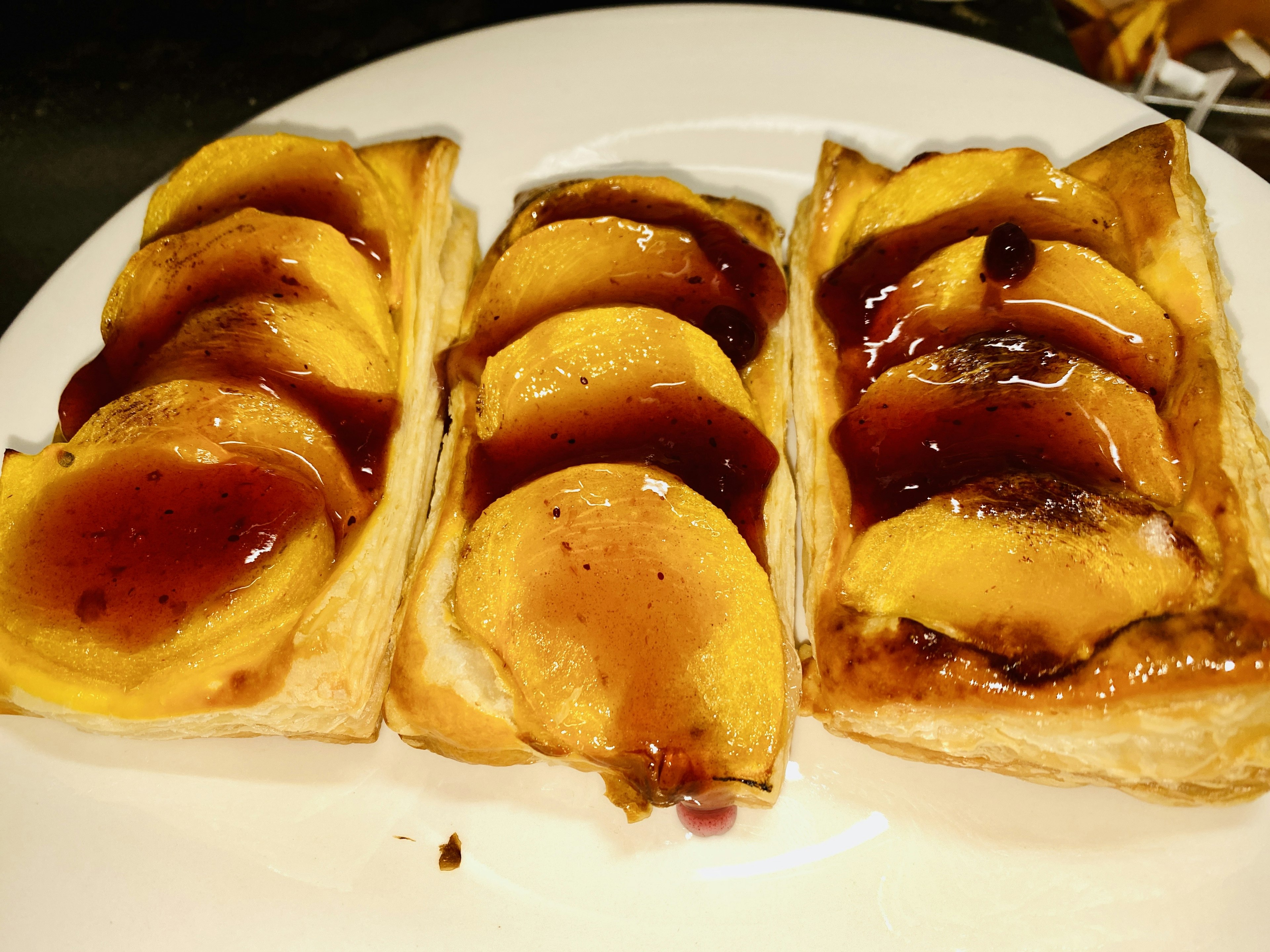 Plato de pasteles cubiertos con rodajas de durazno dulce y mermelada