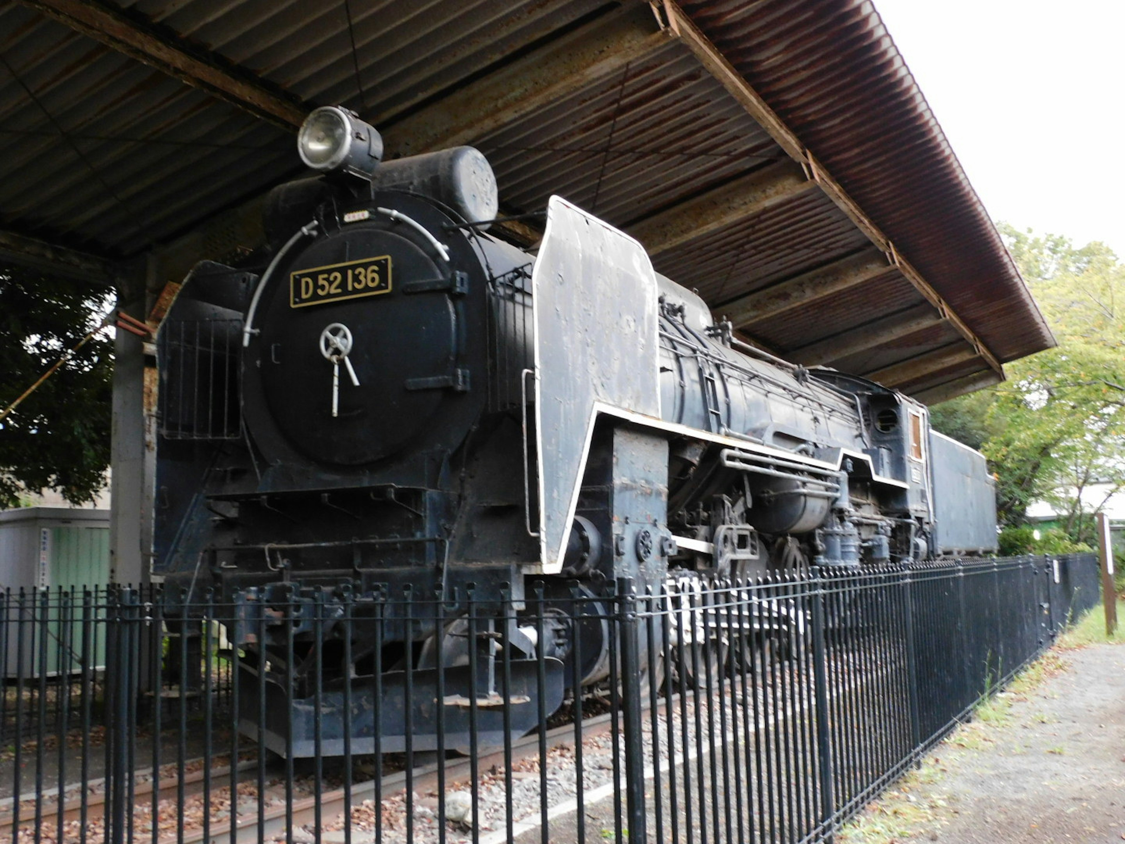 Locomotora de vapor negra exhibida bajo un techo