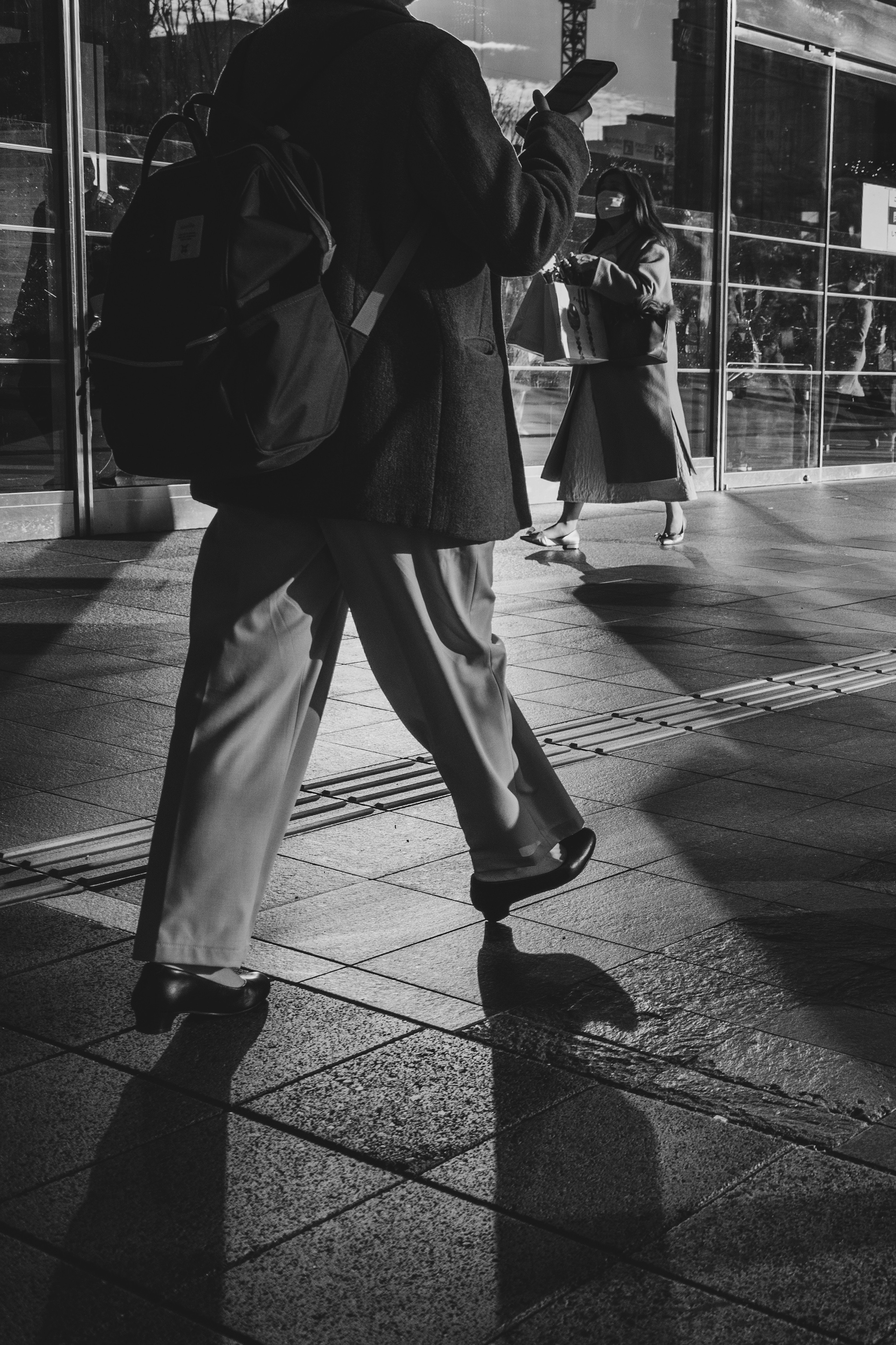 Silhouette einer Person, die in einem Schwarz-Weiß-Foto geht