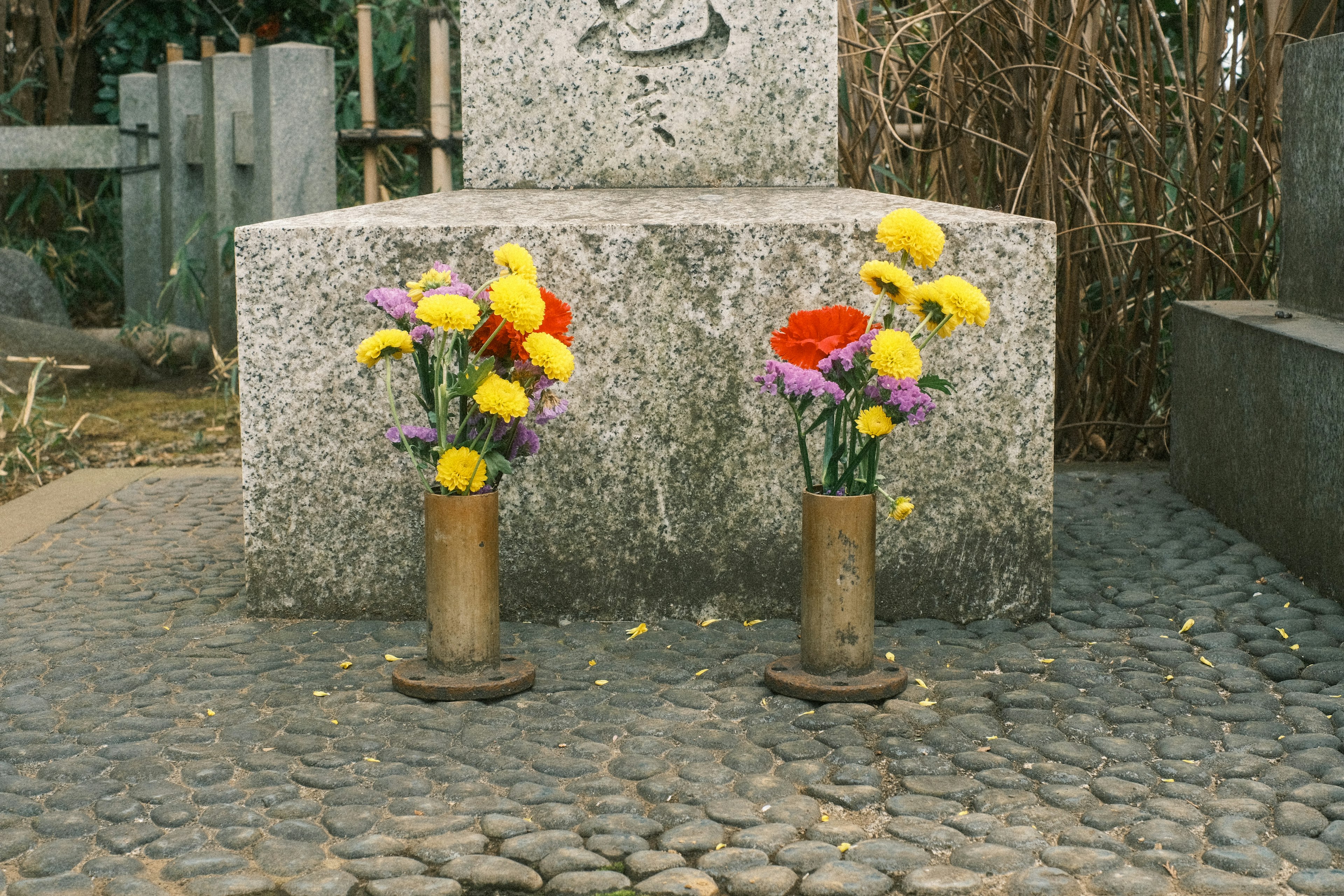 Flores coloridas dispuestas en jarrones en un sitio de entierro