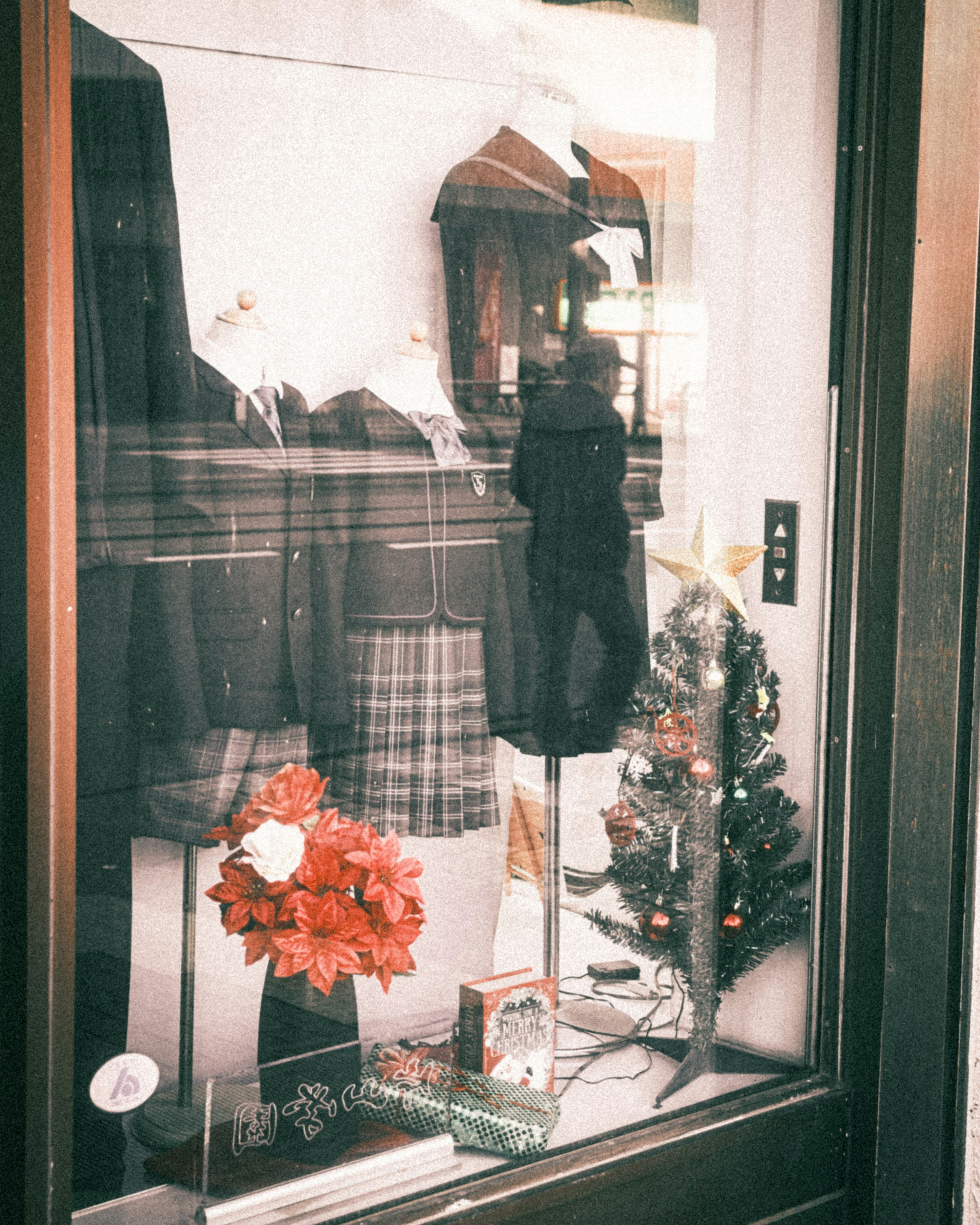 Display window featuring Christmas tree and clothing items