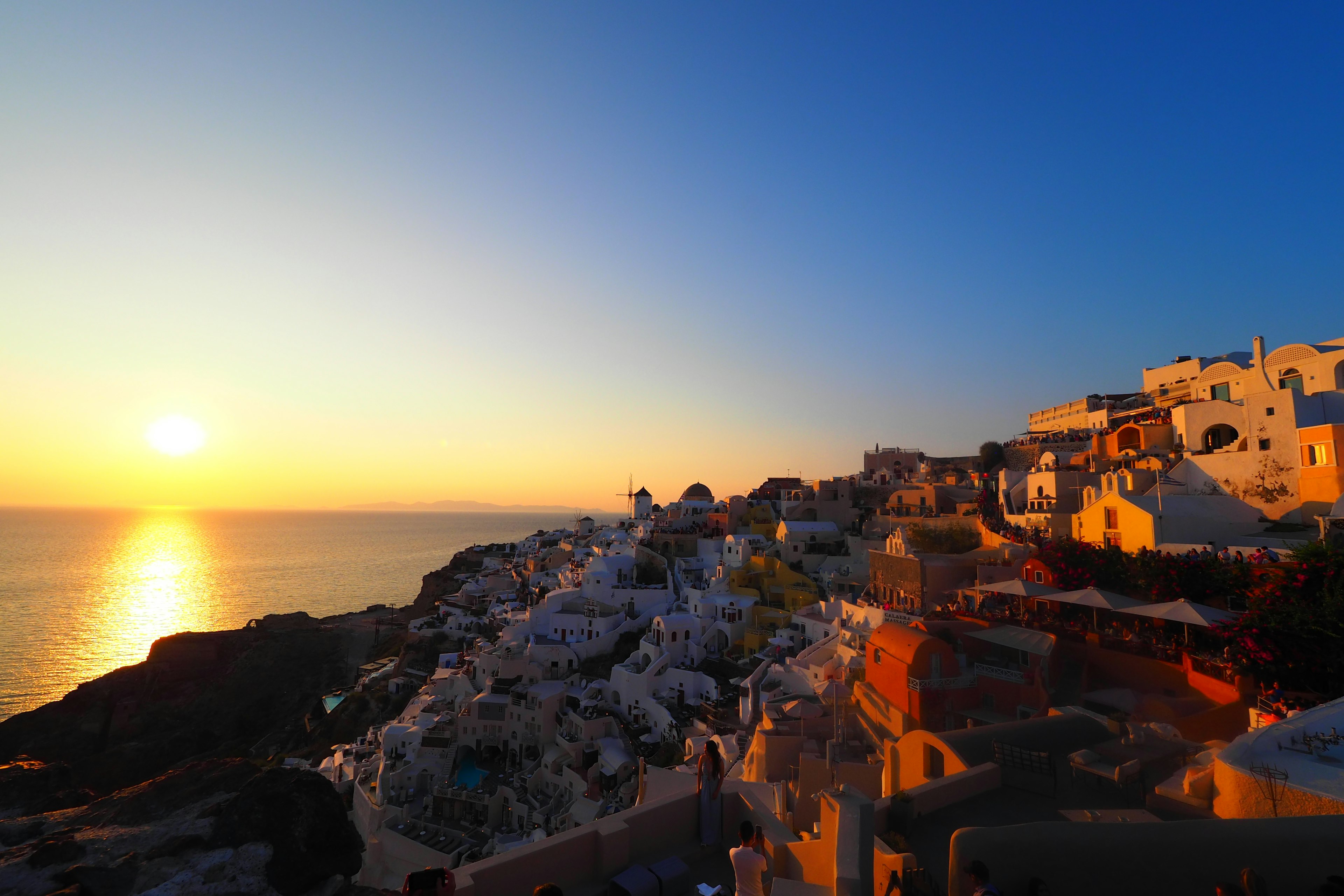 Atardecer en Santorini con edificios blancos y vista al océano