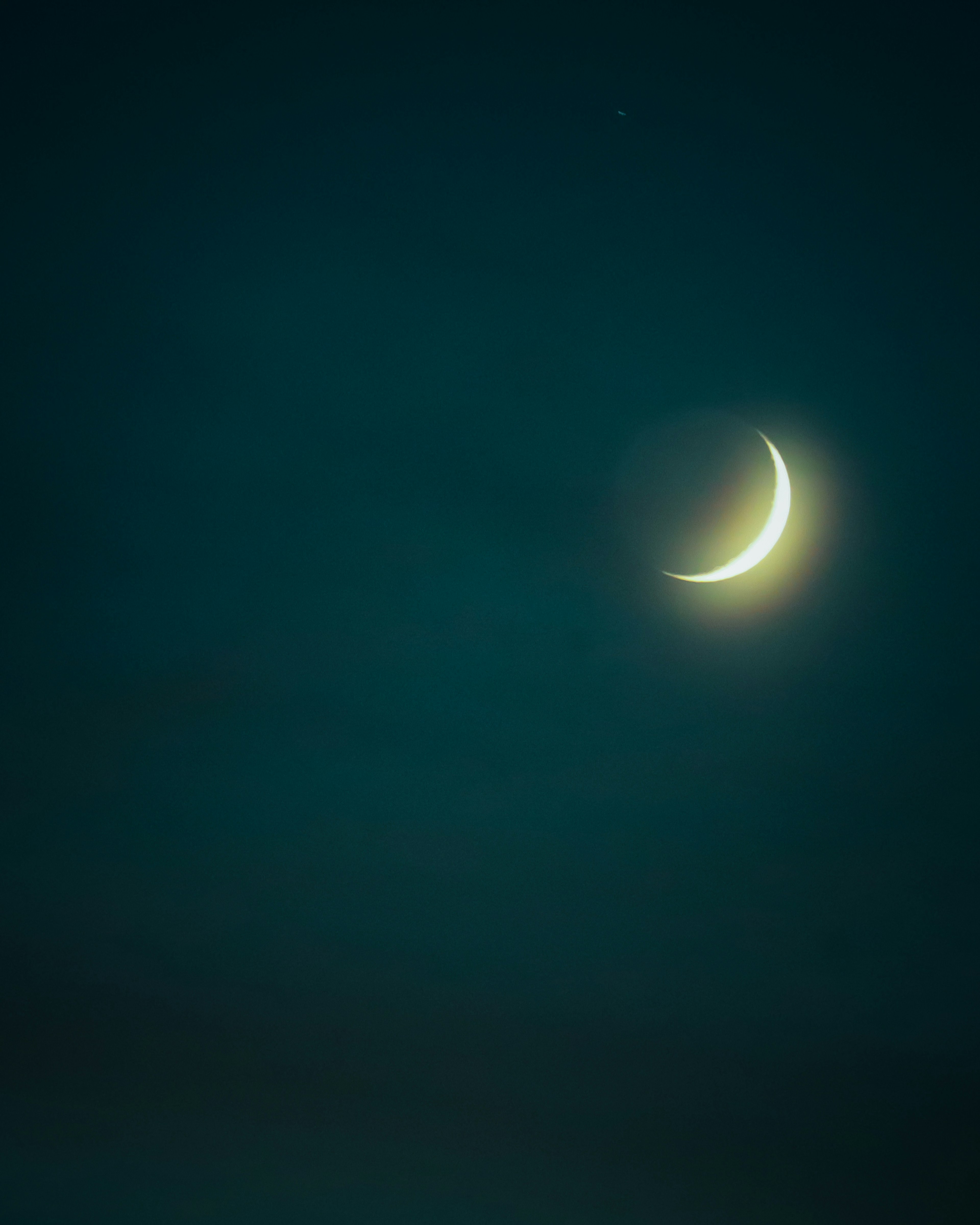 Une lune croissante brillant dans un ciel bleu foncé