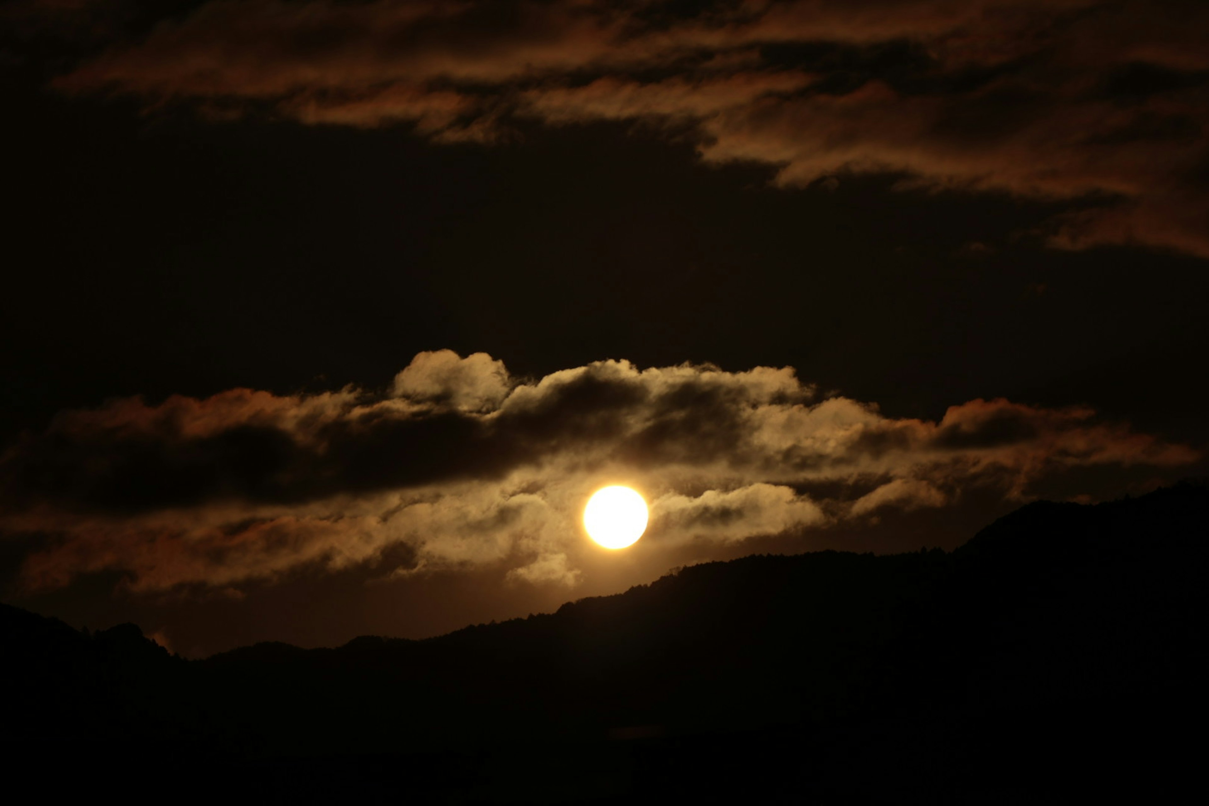 Sonnenuntergang mit Wolken im dunklen Himmel