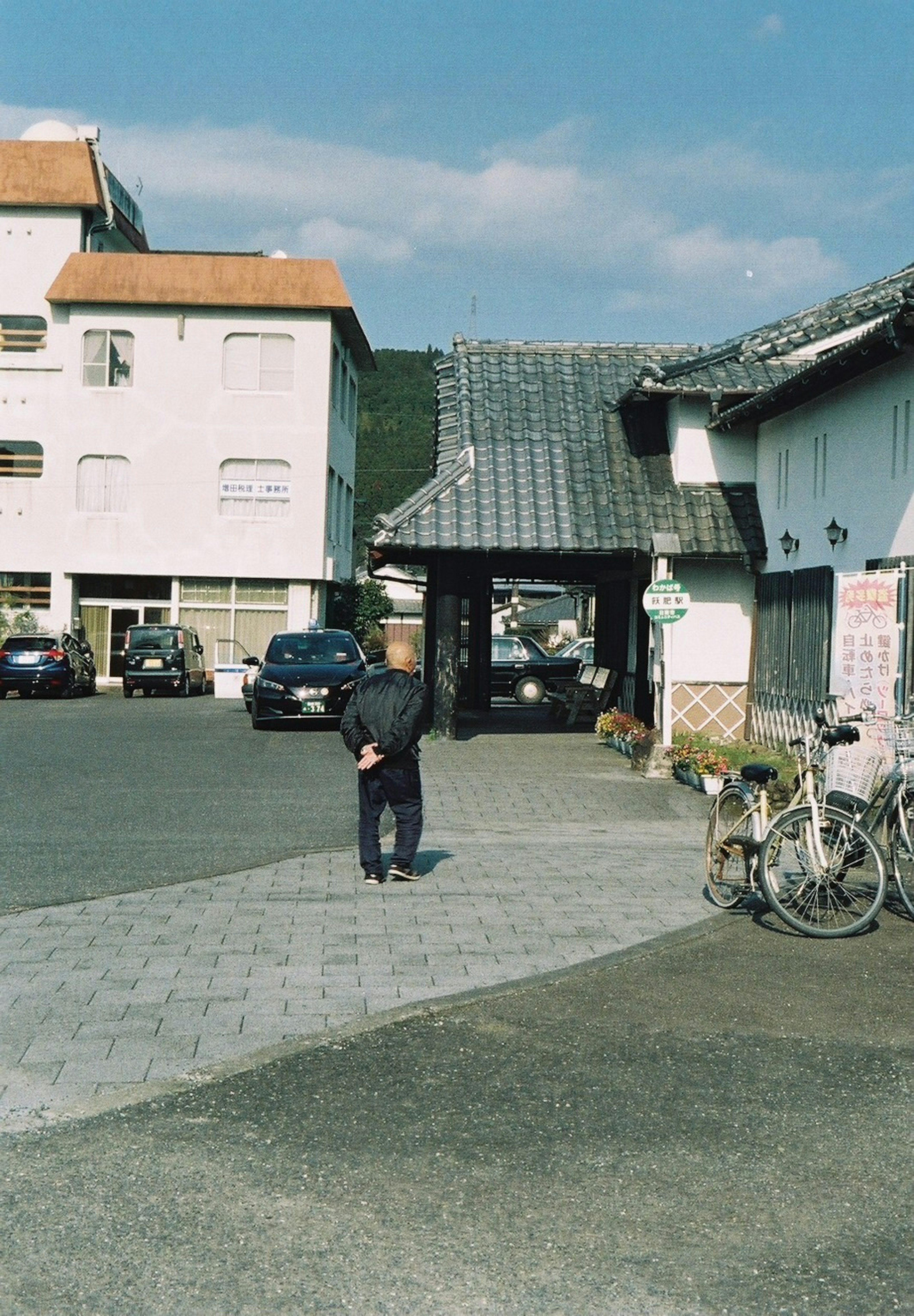 Scenic view of an old Japanese town with a person standing and bicycles