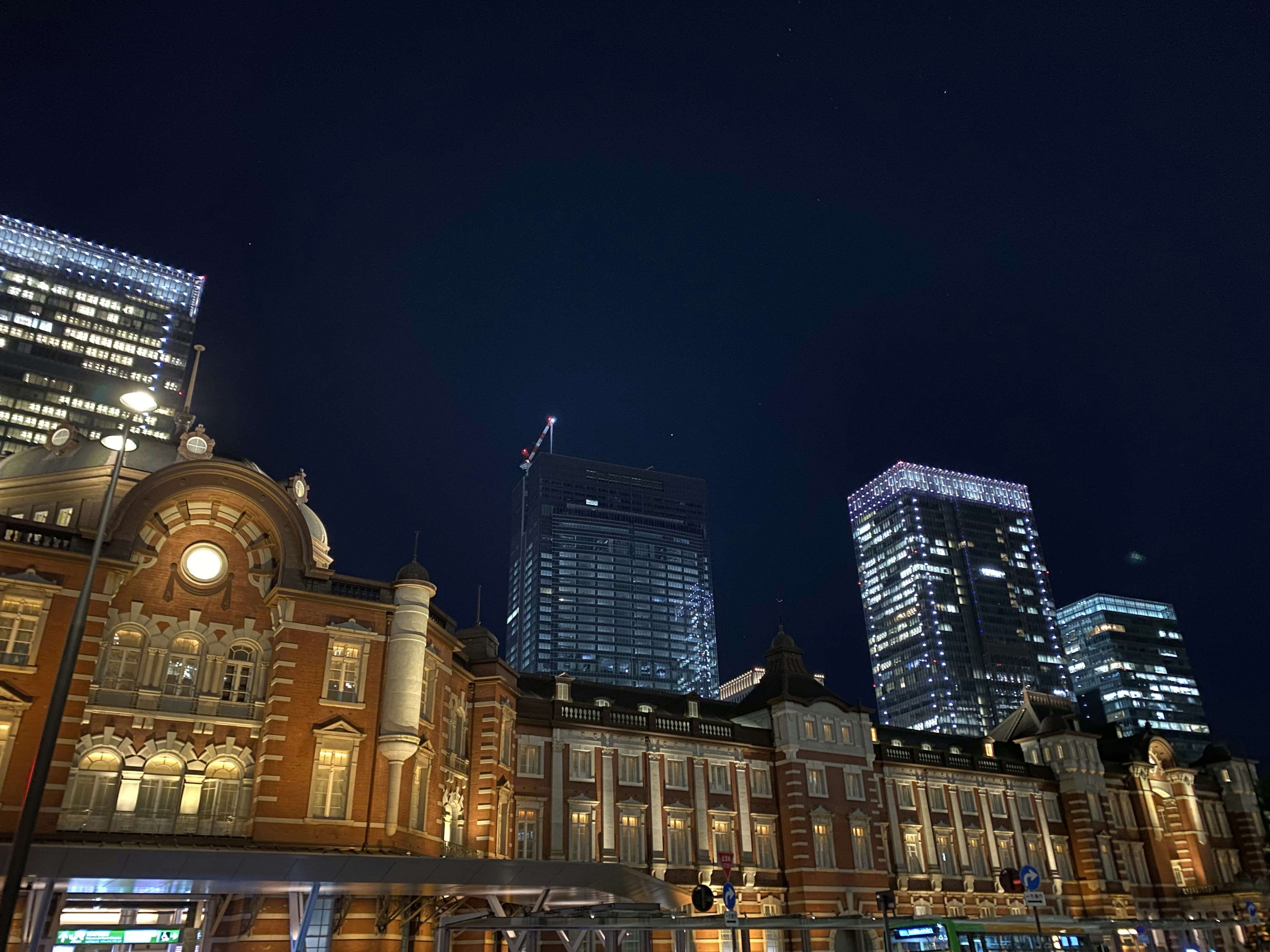 Contraste de la estación de Tokio y los rascacielos de noche