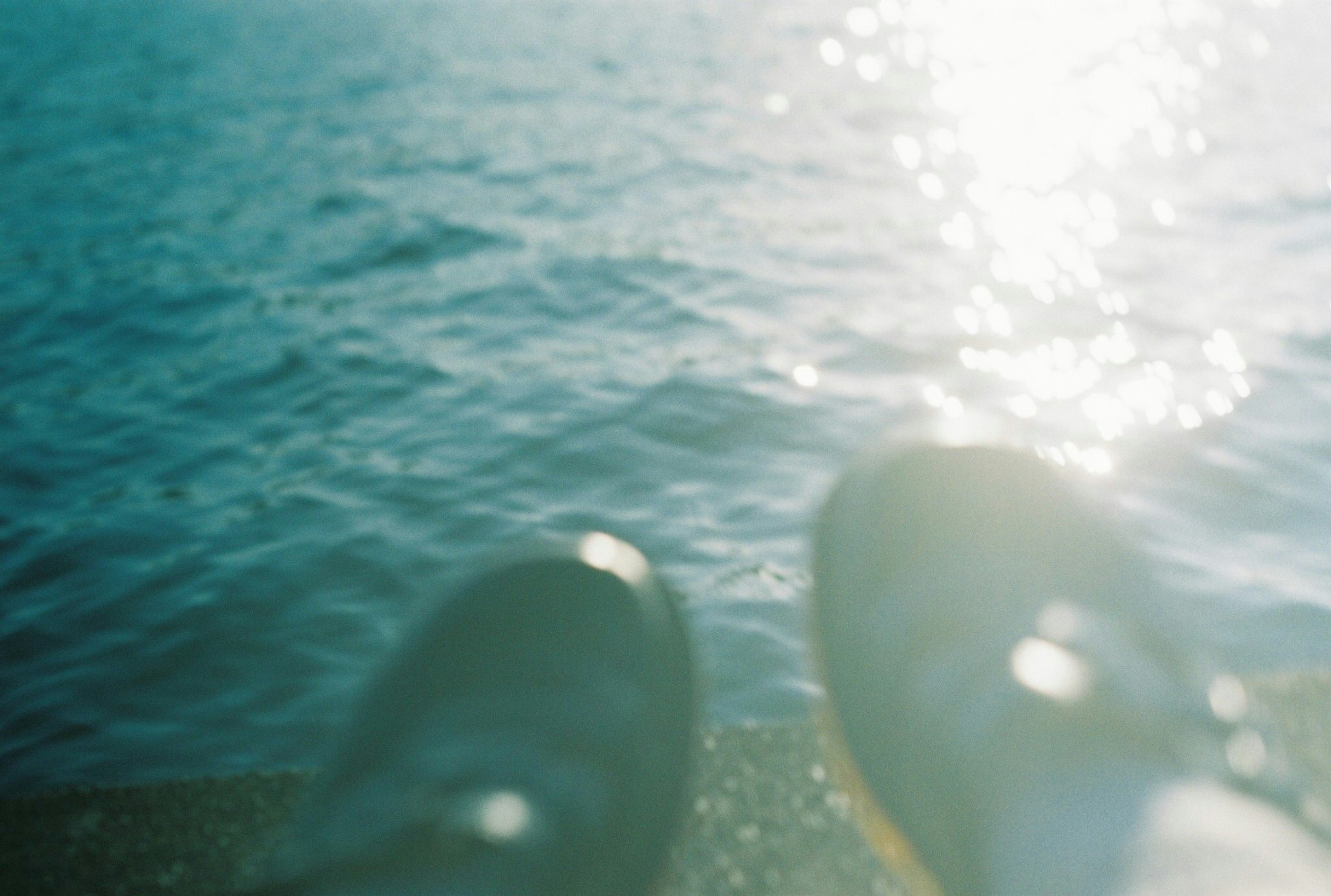 Zapatos negros mirando una superficie de agua brillante