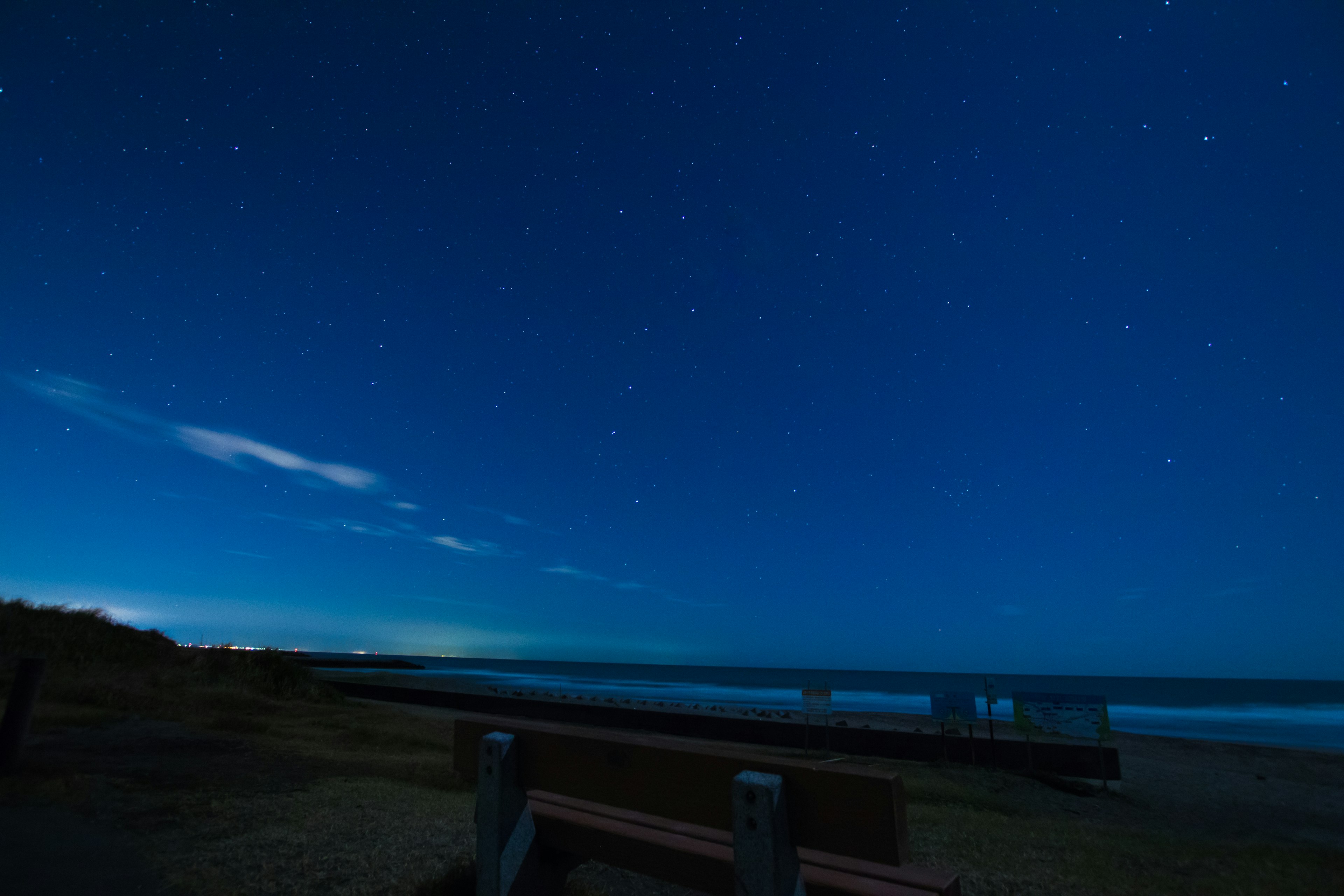 Vue nocturne d'un ciel étoilé au-dessus de la côte avec des nuages