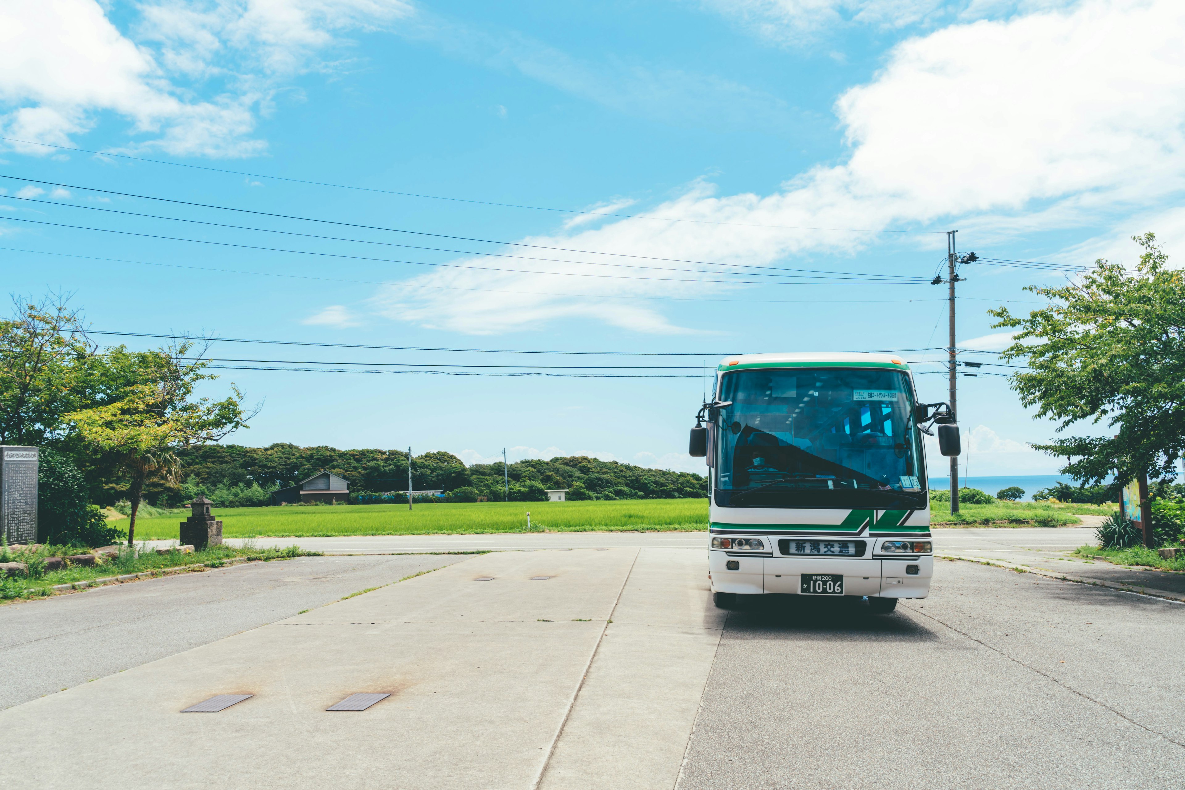 一輛公車停在藍天和綠色田野前