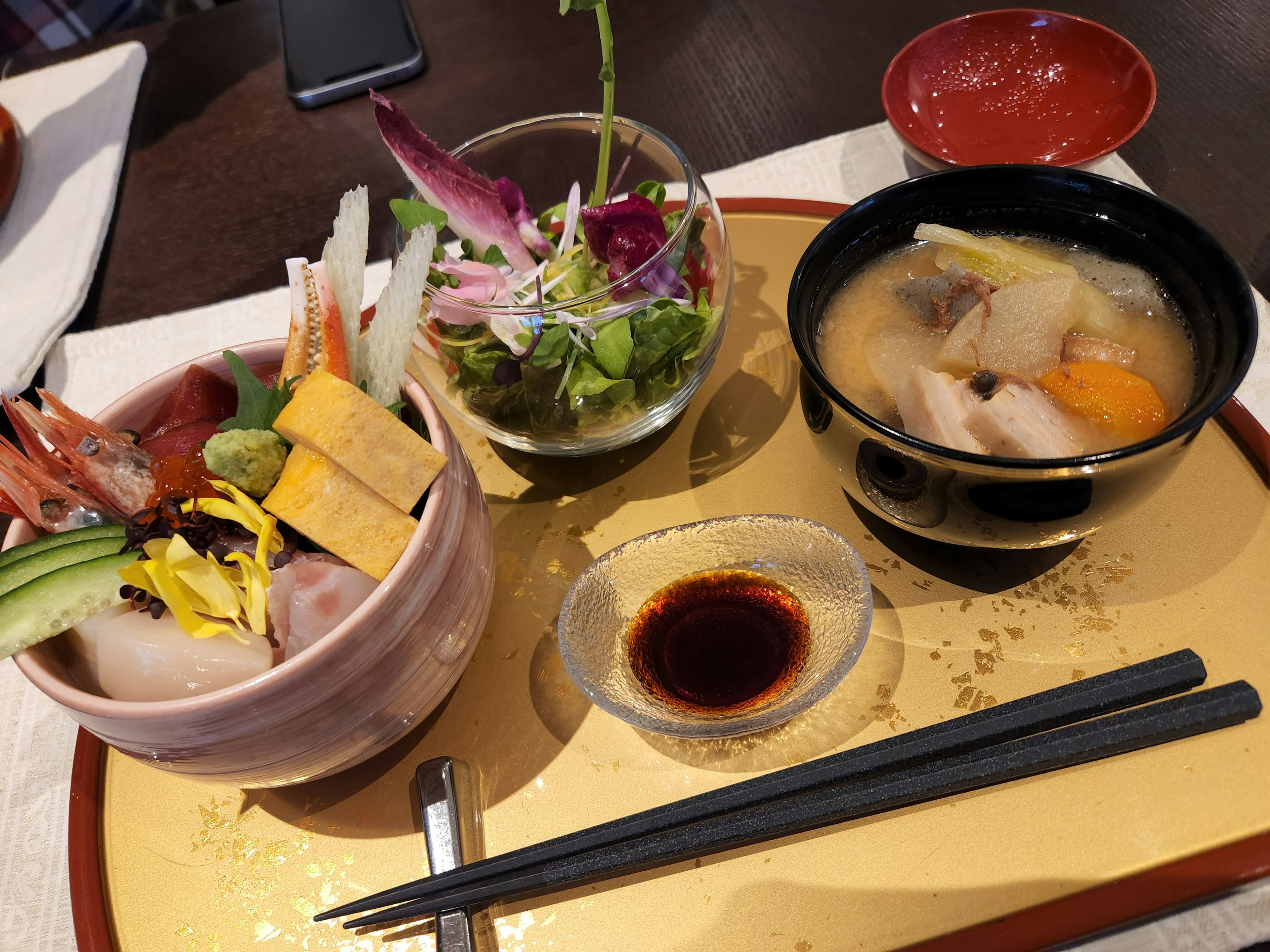 Plat de cuisine japonaise avec bol de sashimi salade et soupe miso