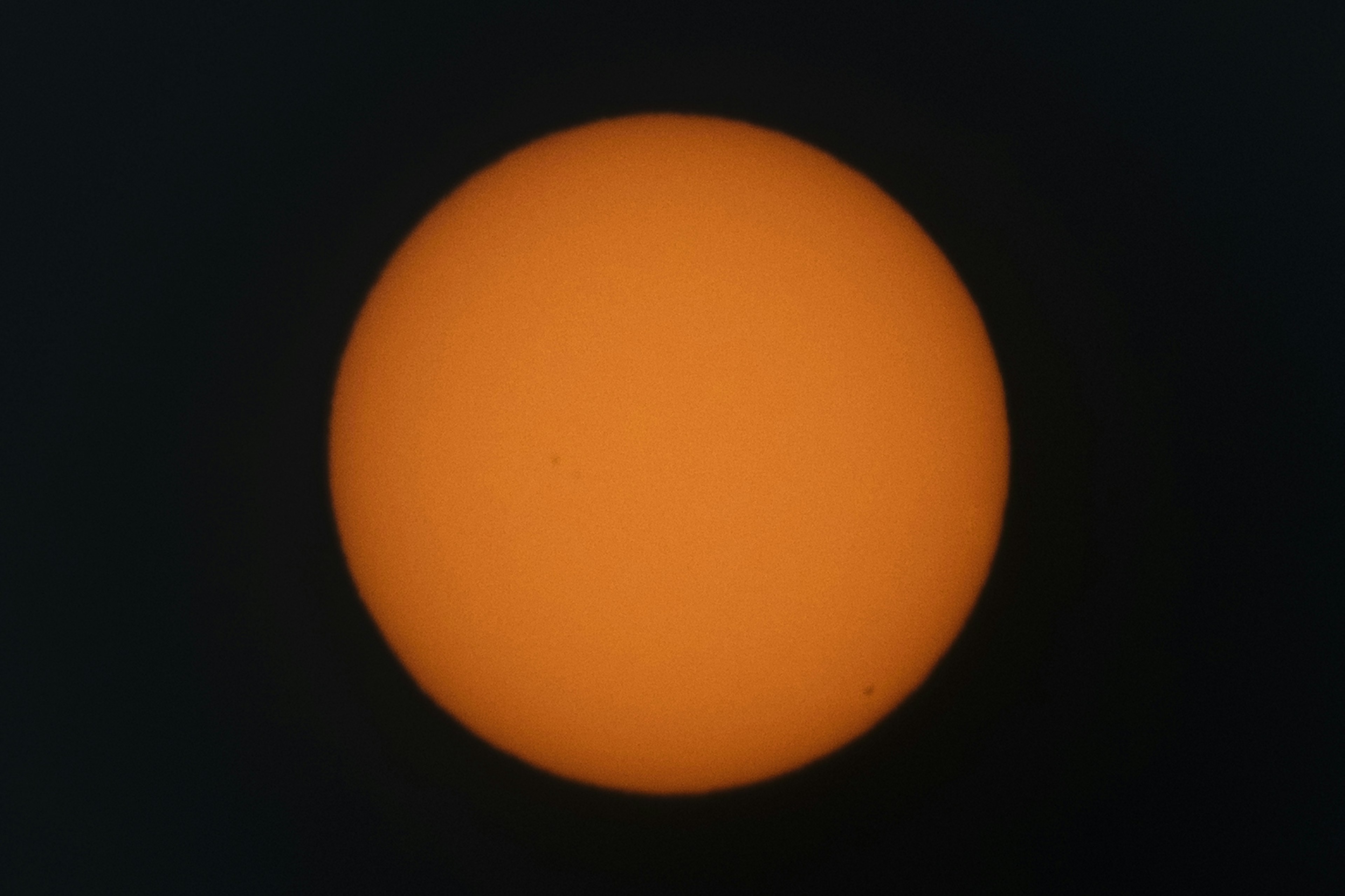 Un sol naranja brillante contra un fondo oscuro