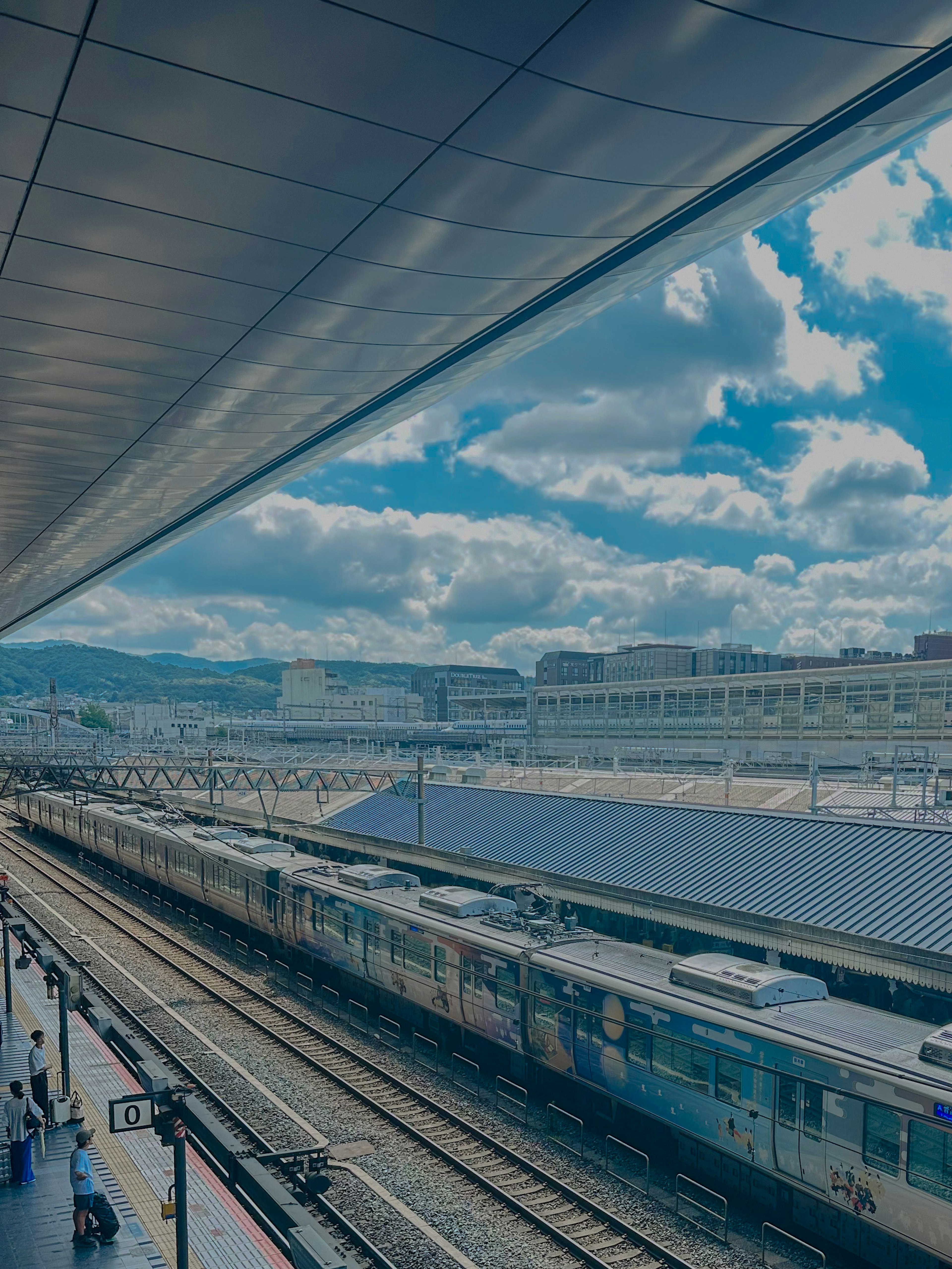 Vista de un tren y cielo azul desde una plataforma de estación