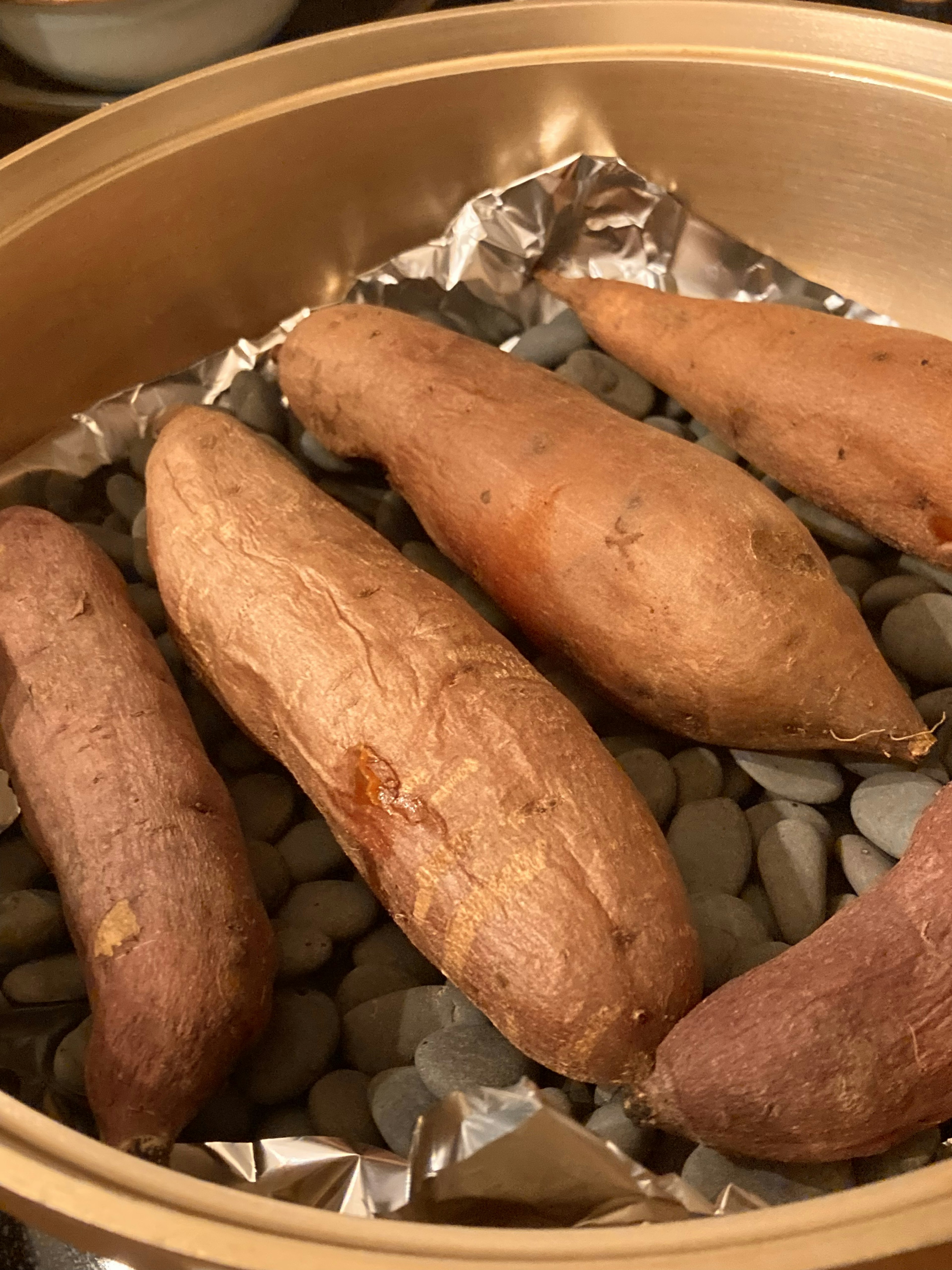 Batatas dulces dispuestas en una vaporera con piedras