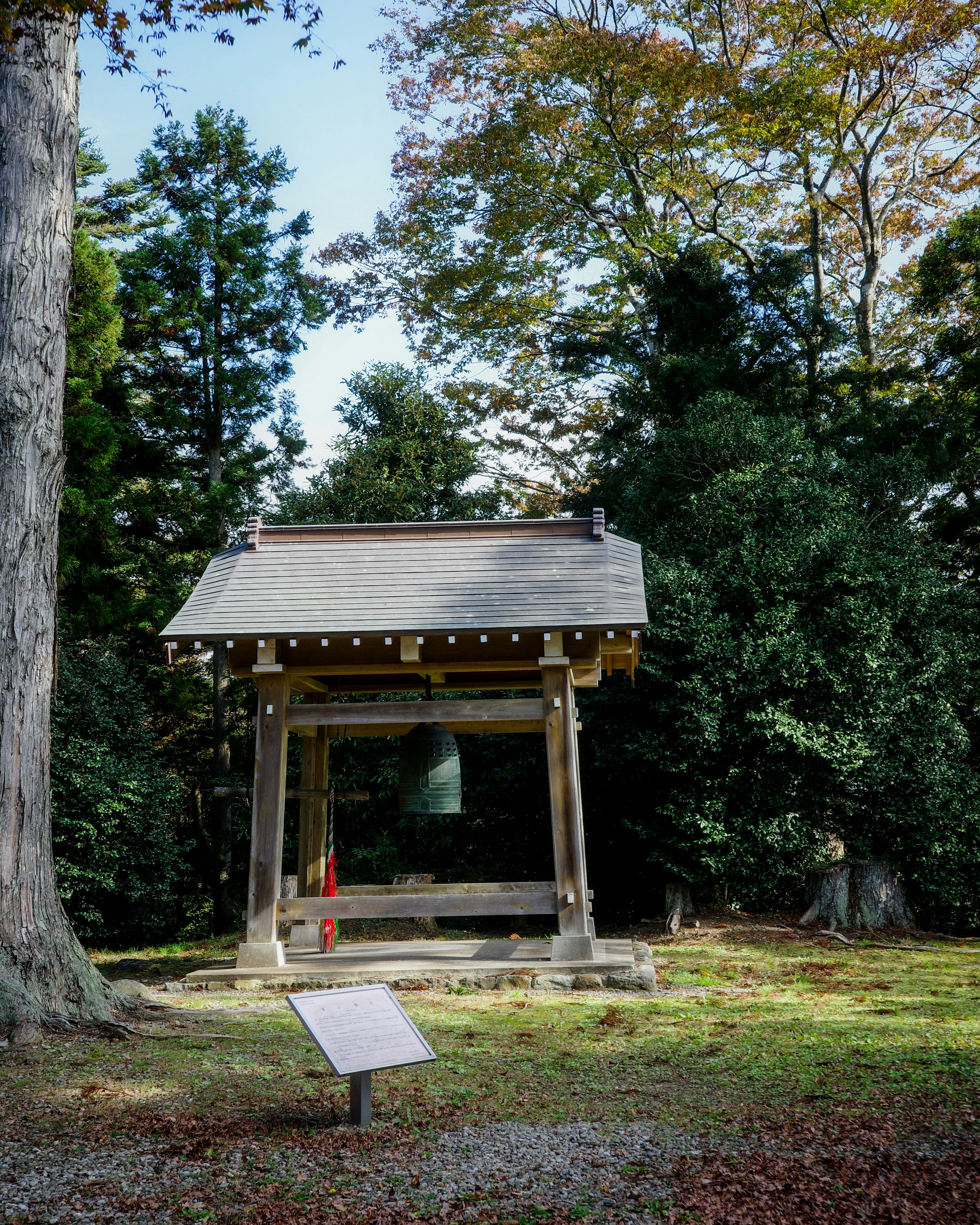 静かな公園の中にある鐘楼と緑の木々