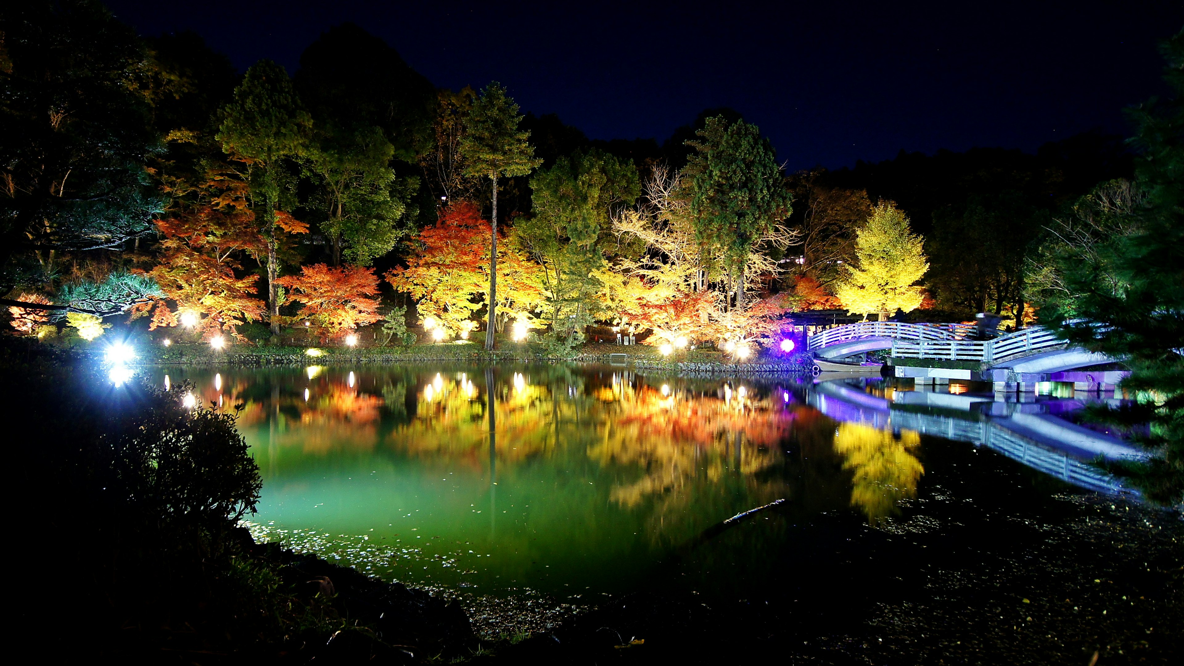 Scenic view of a lake at night with vibrant autumn foliage reflections