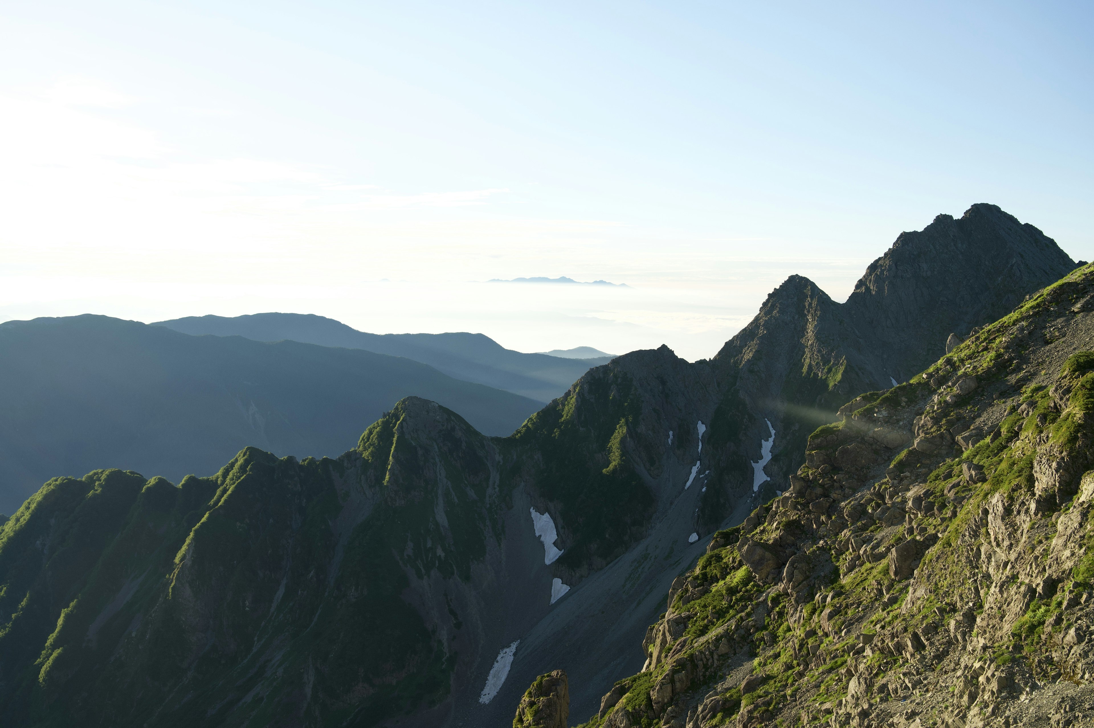 Vue panoramique de montagnes vertes sous un ciel bleu clair