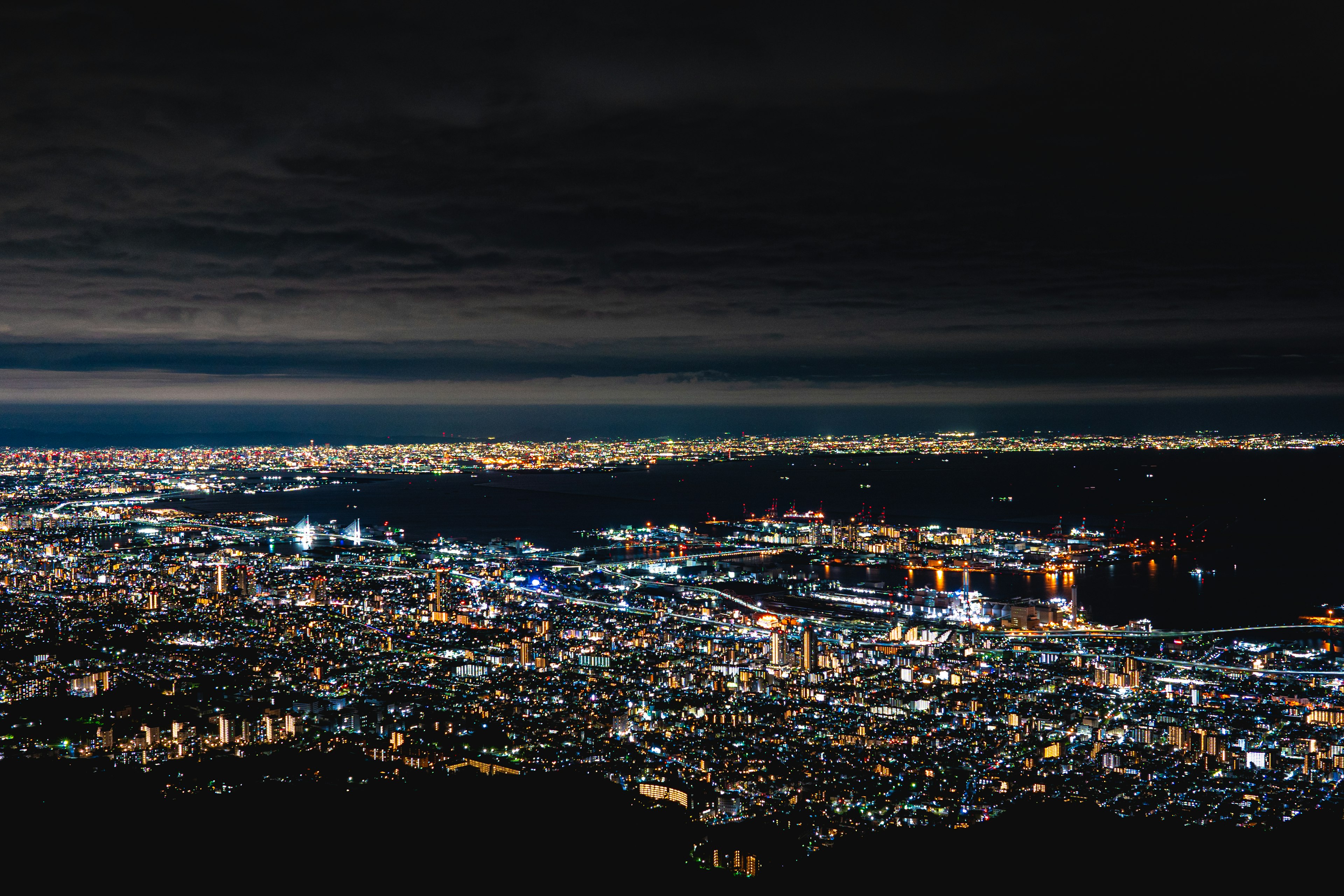 Paesaggio urbano notturno con luci brillanti che si estendono nel paesaggio