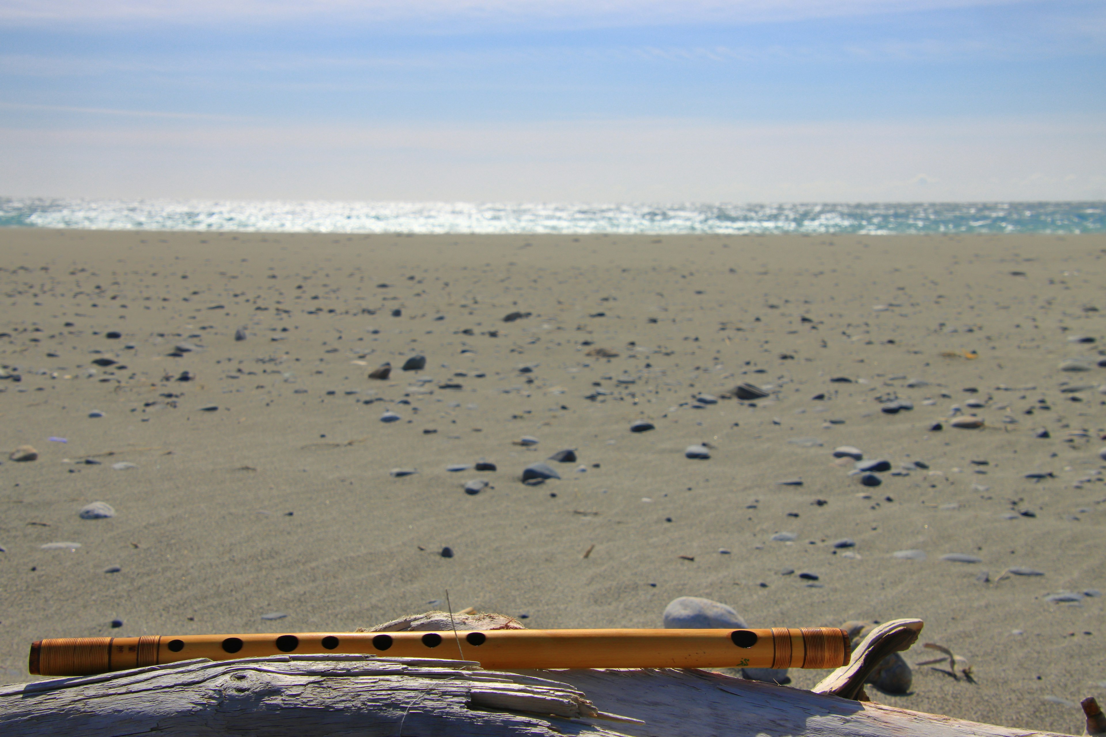 Scenic beach view with a wooden flute on the sand