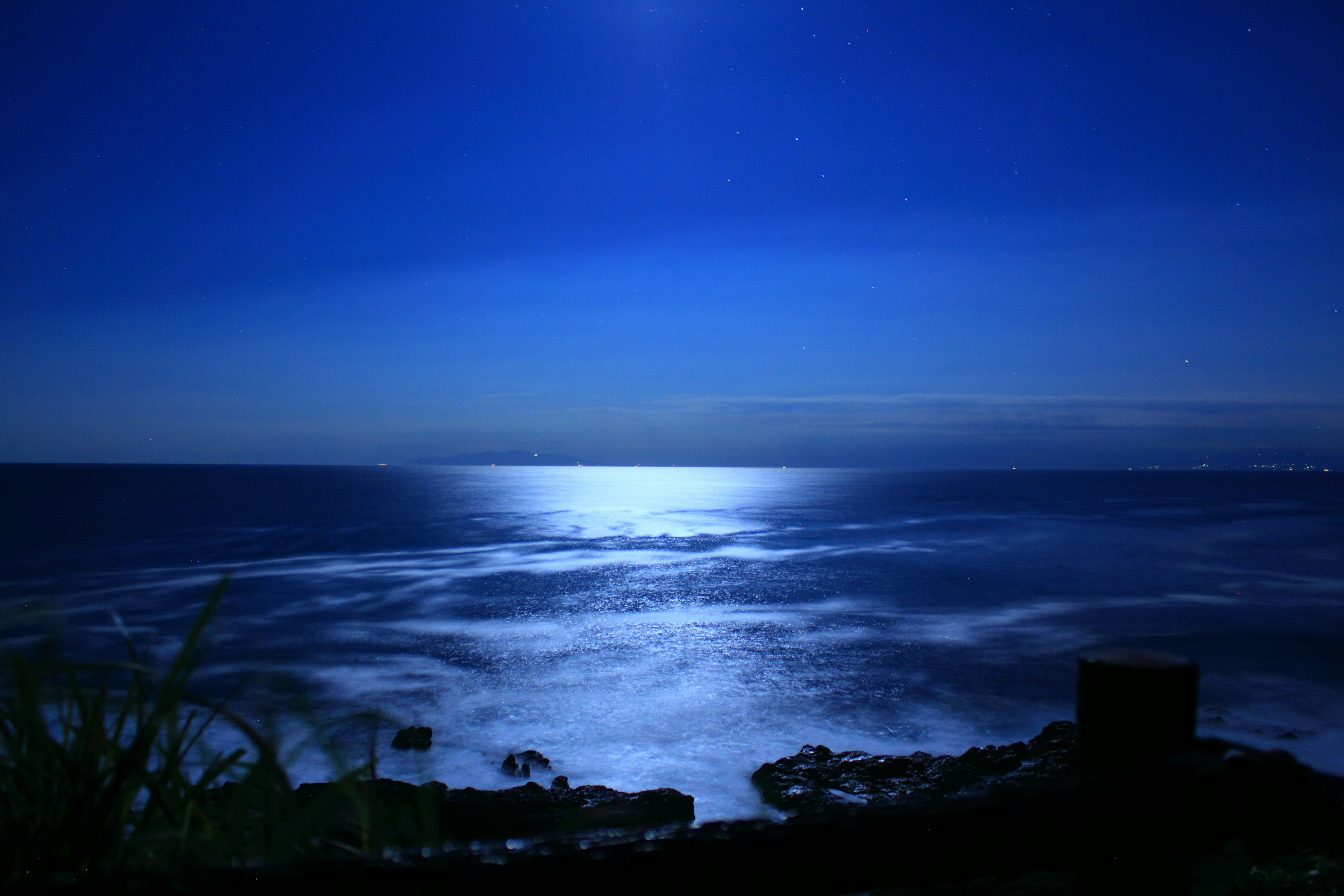 Belle scène nocturne de l'océan avec la lumière de la lune se reflétant sur l'eau