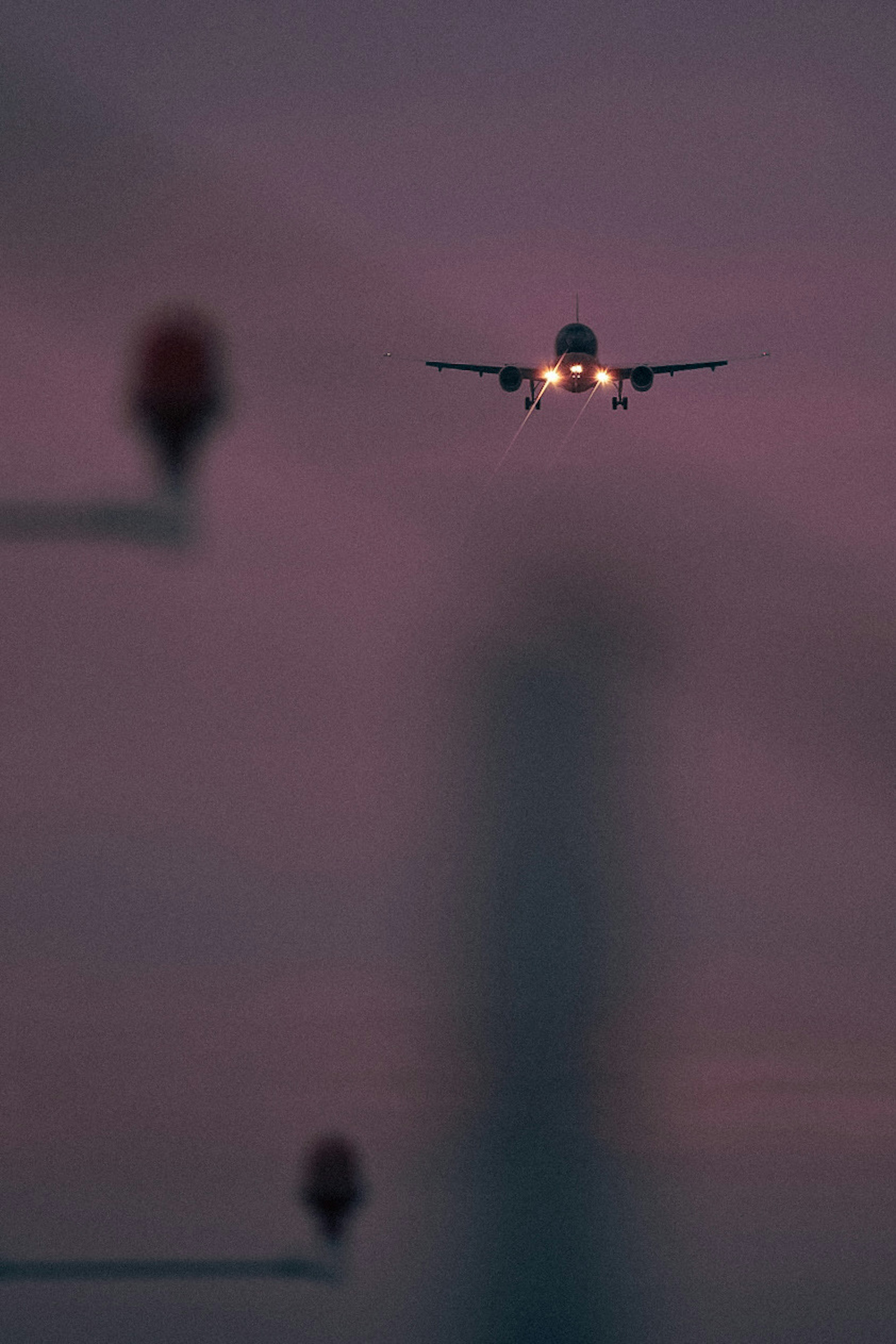 An airplane approaching against a sunset sky