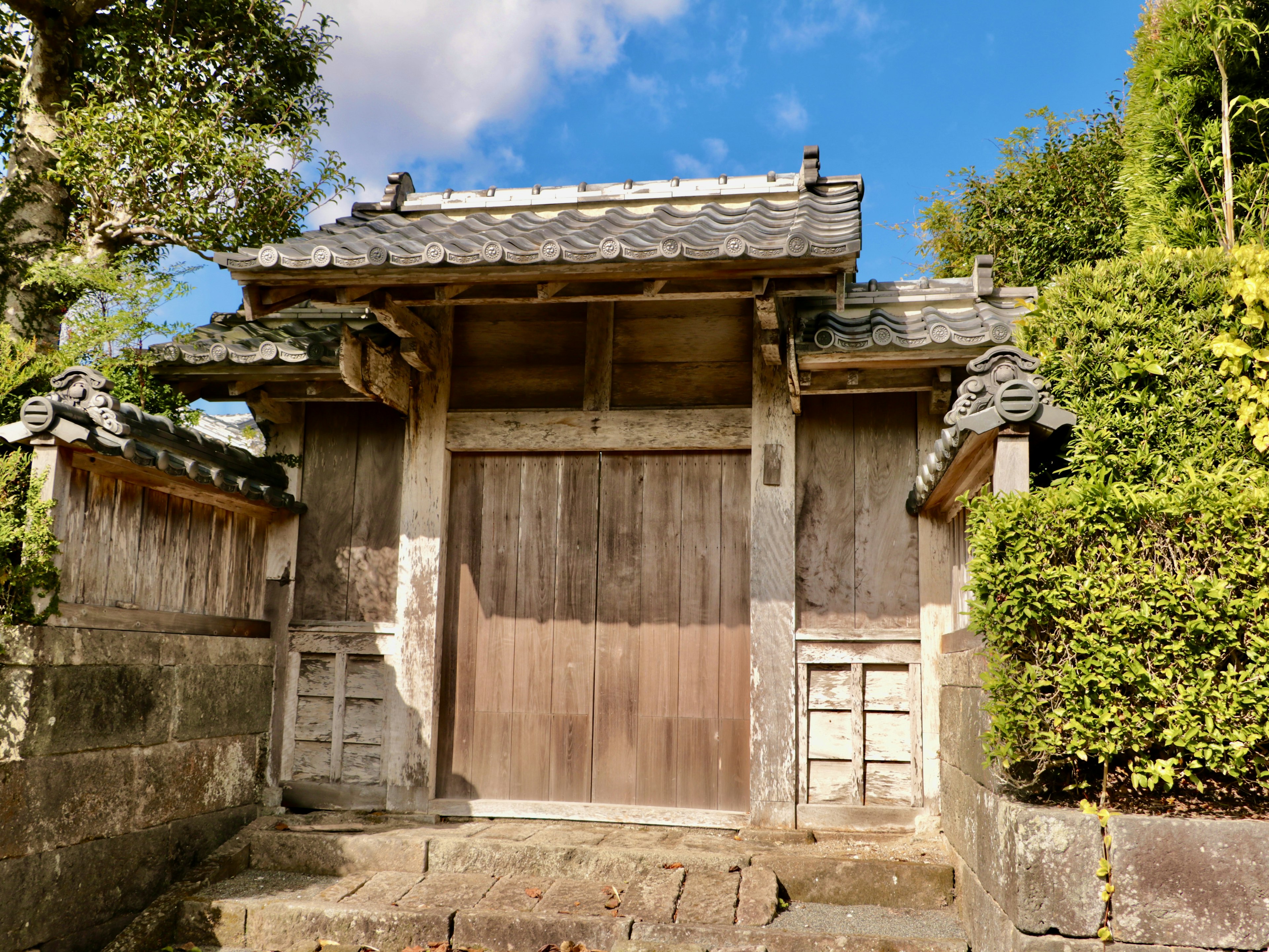 Traditional Japanese building with an old wooden gate and stone steps