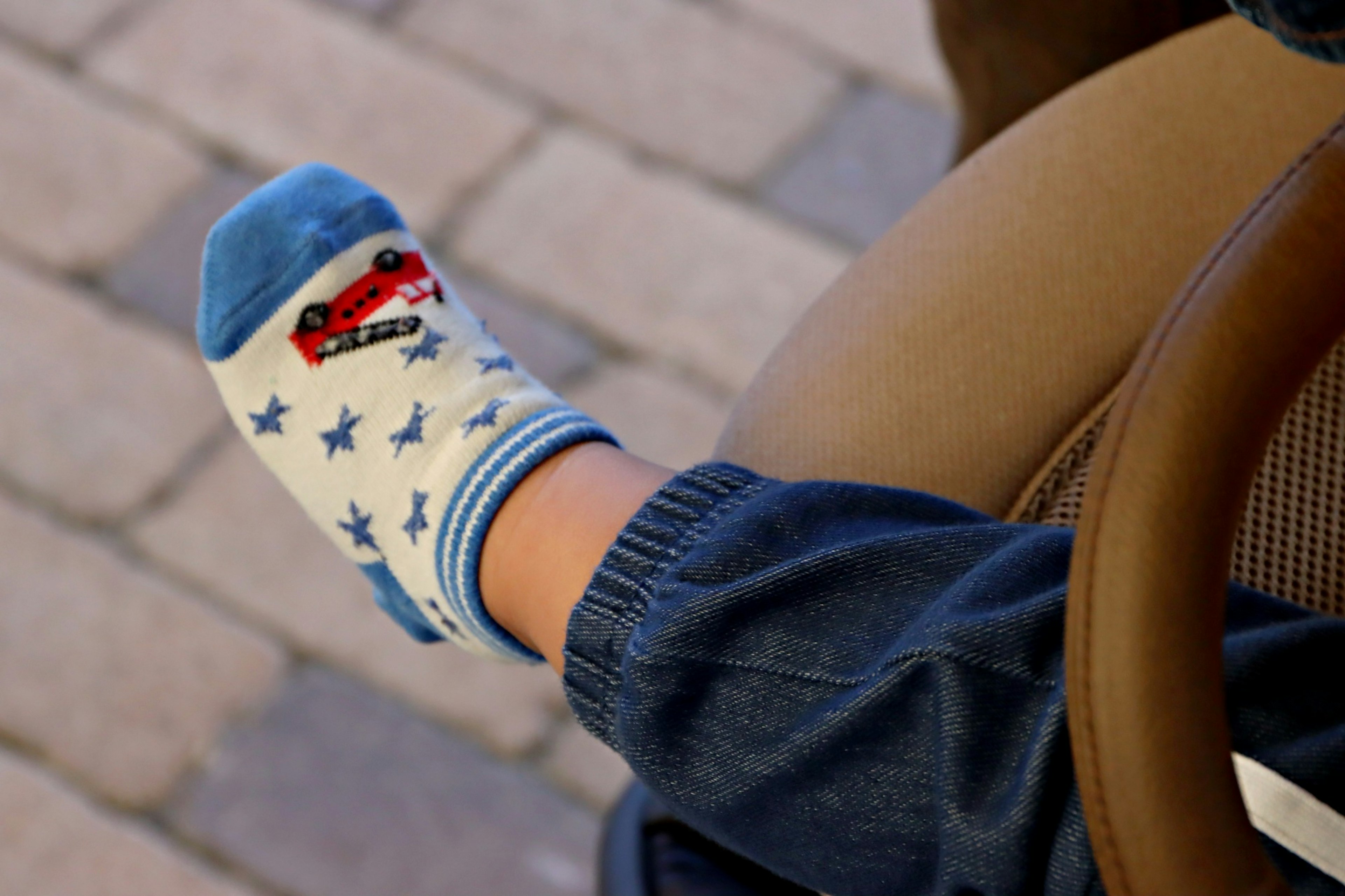 Fuß eines Kindes mit einer Socke mit blauem Auto-Motiv