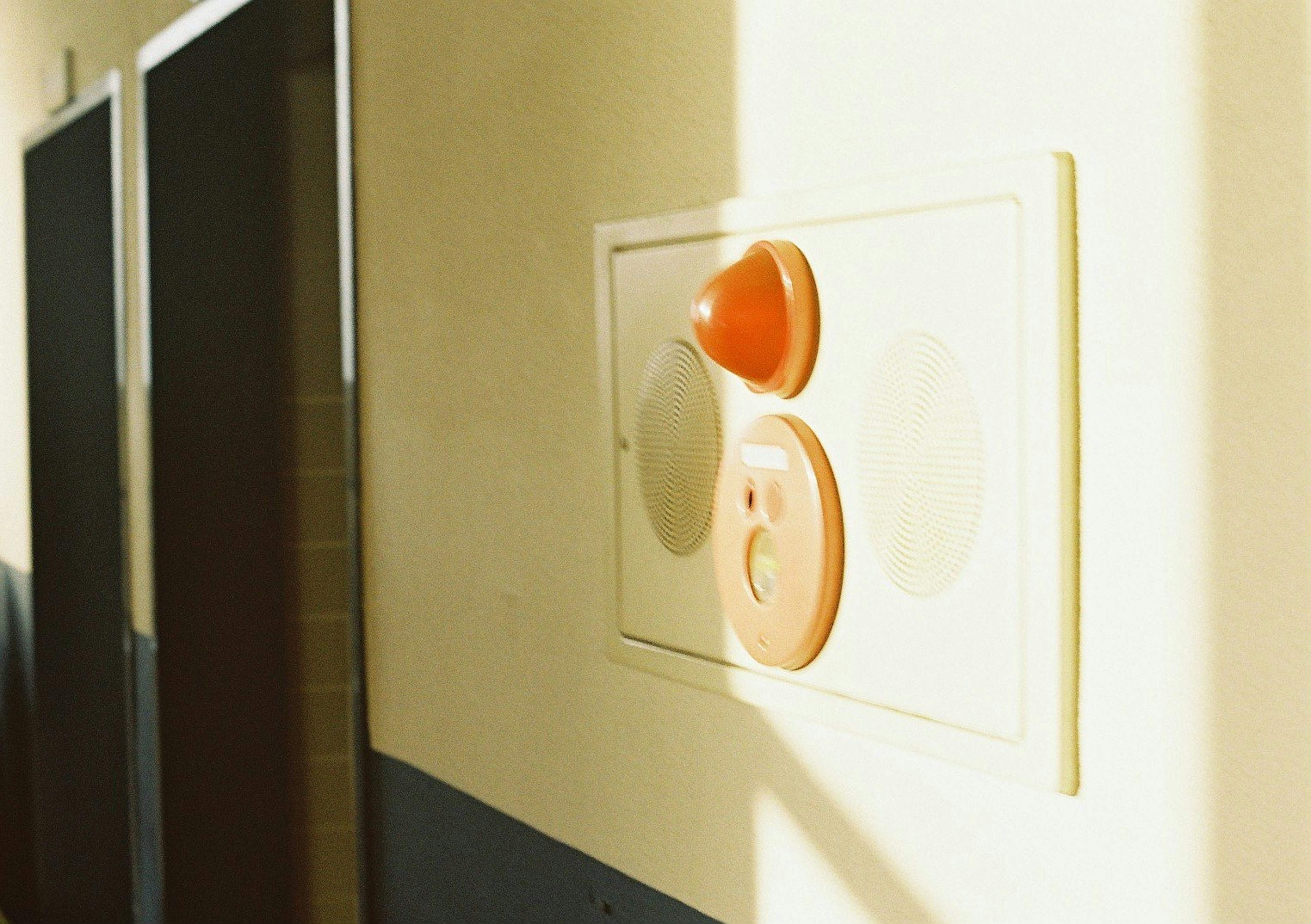 Photo d'un interrupteur orange et d'une prise fixés à un mur