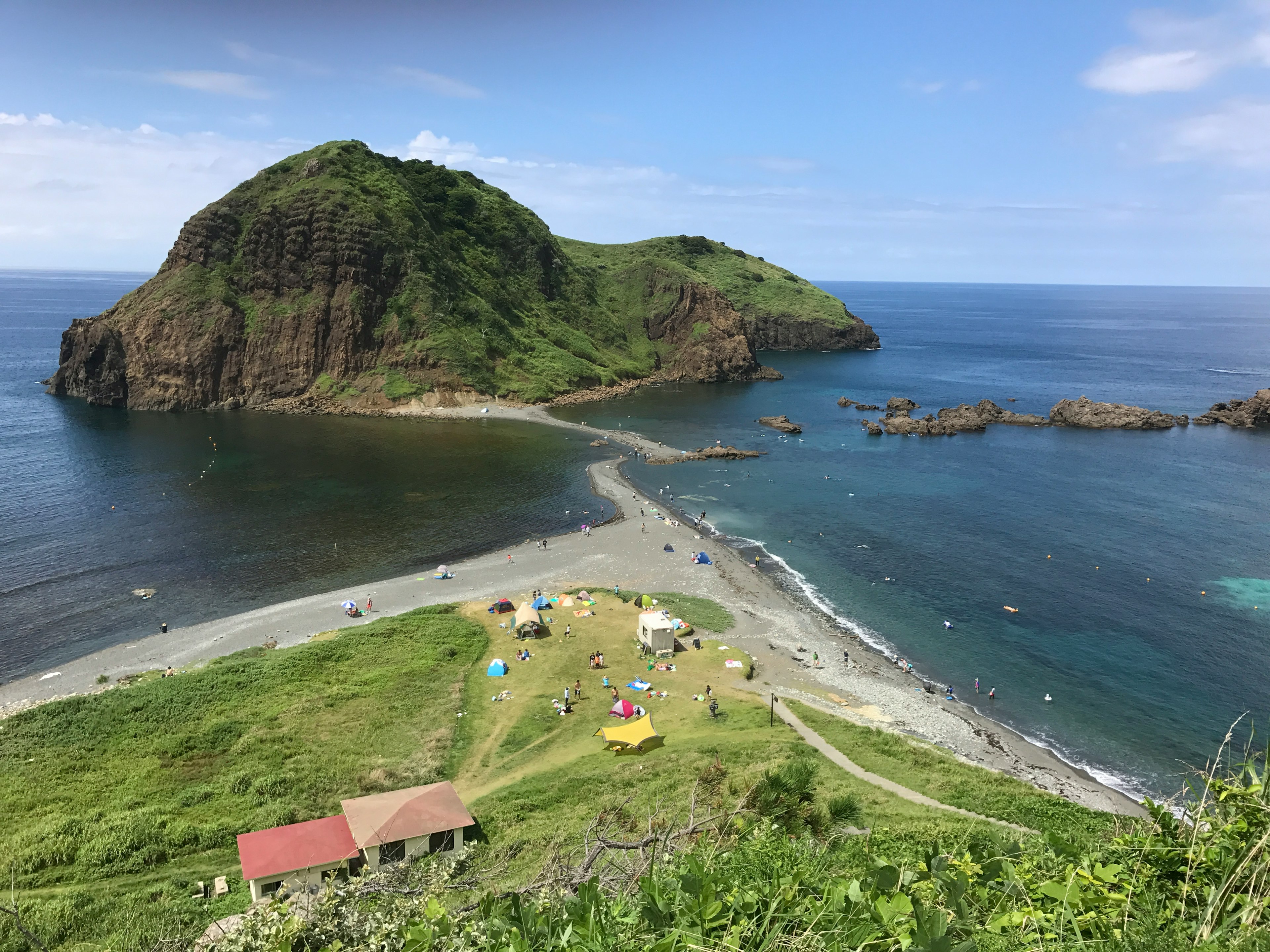 Scenic view of a green island surrounded by blue ocean