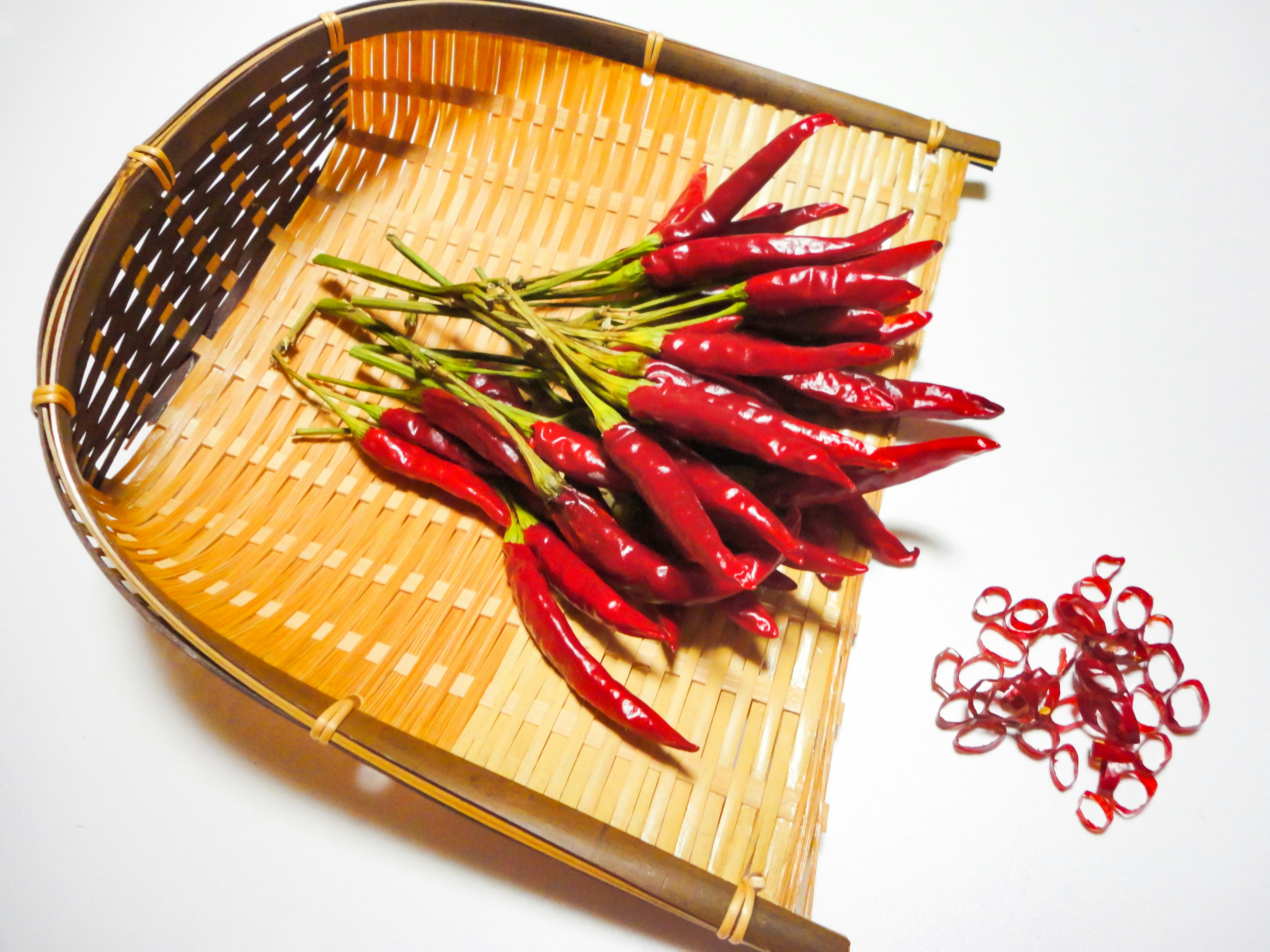 A bunch of red chili peppers placed on a bamboo basket