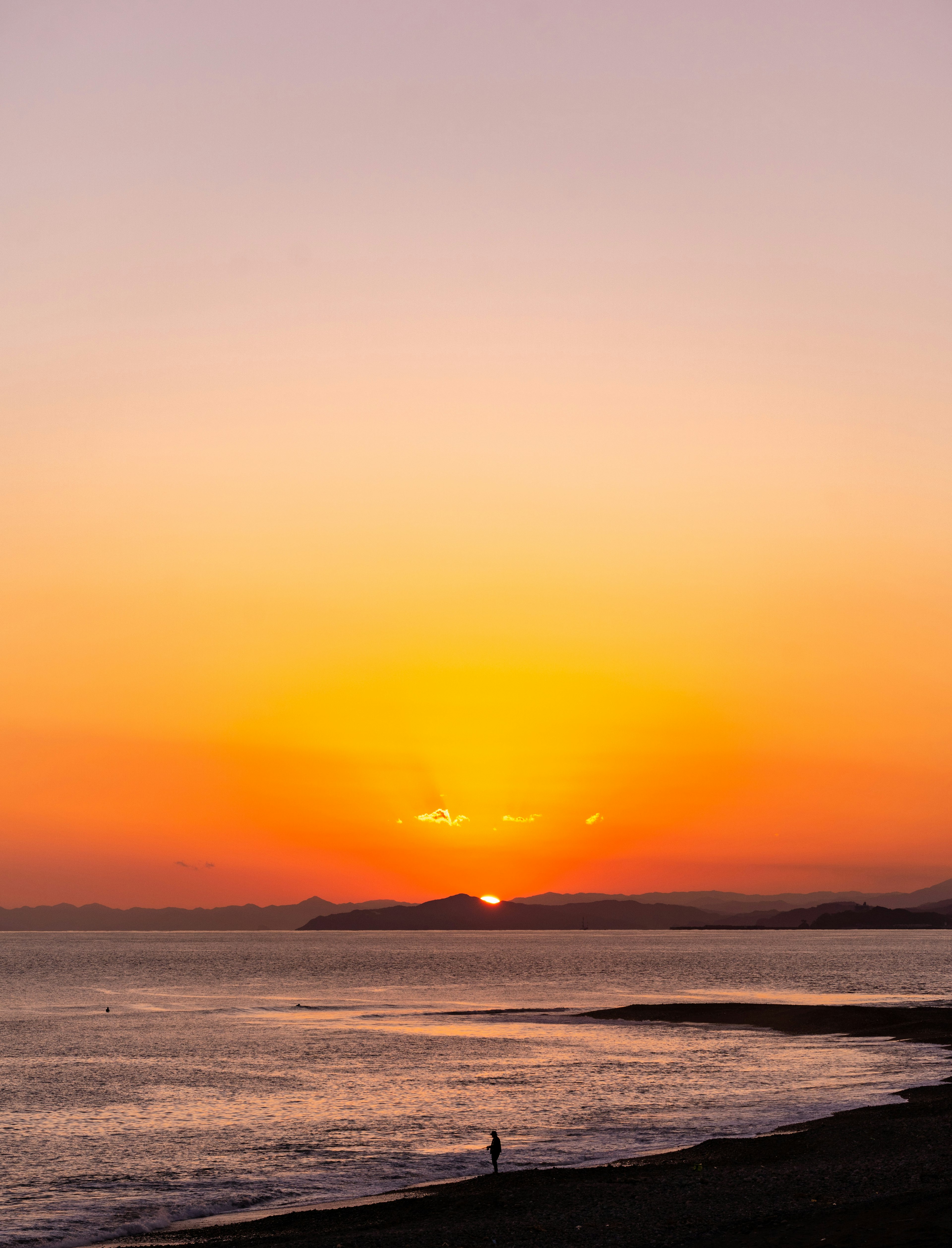 Magnifique coucher de soleil sur l'océan avec la silhouette d'une personne