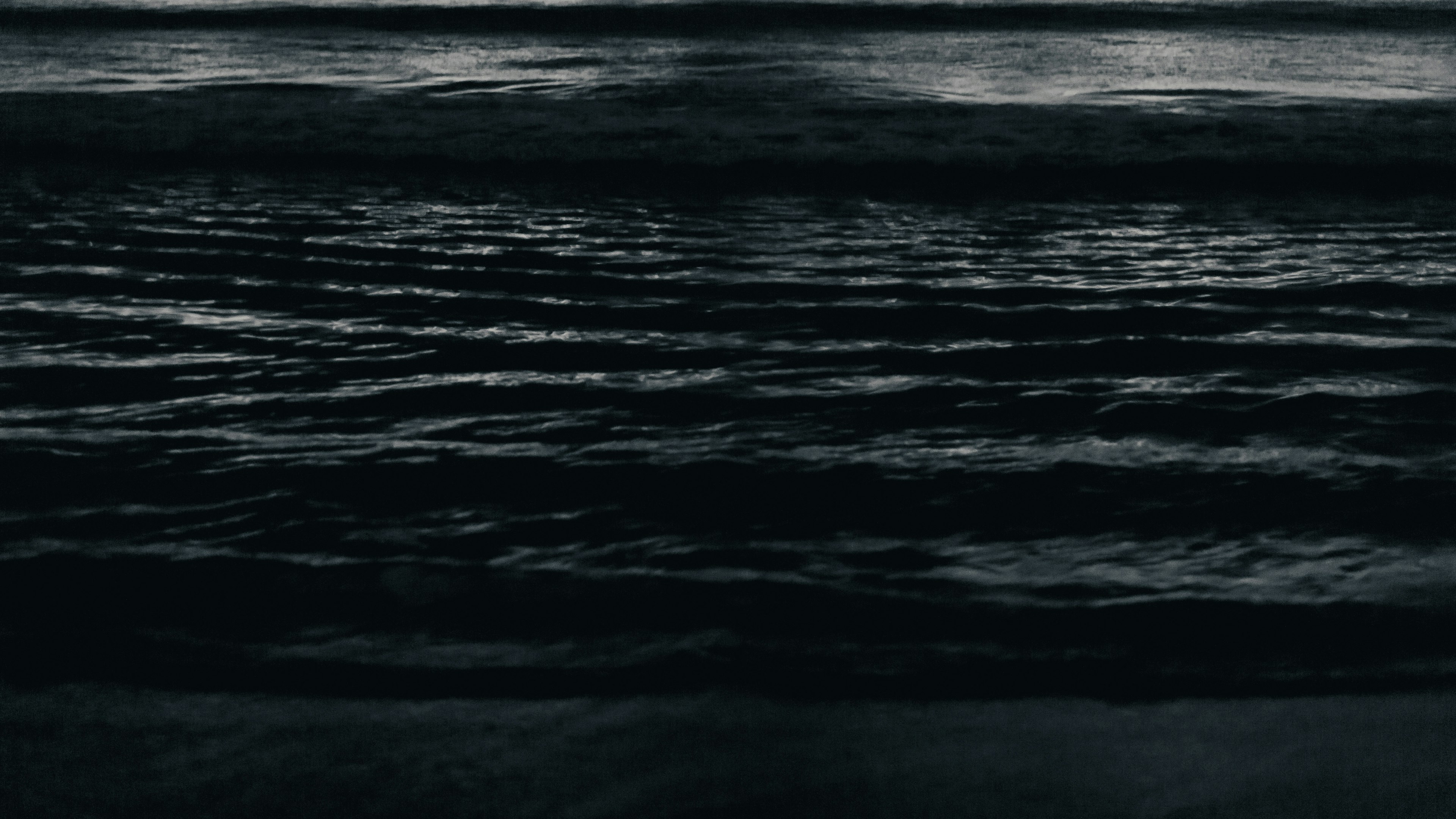 A serene image capturing dark ocean waves with gentle ripples