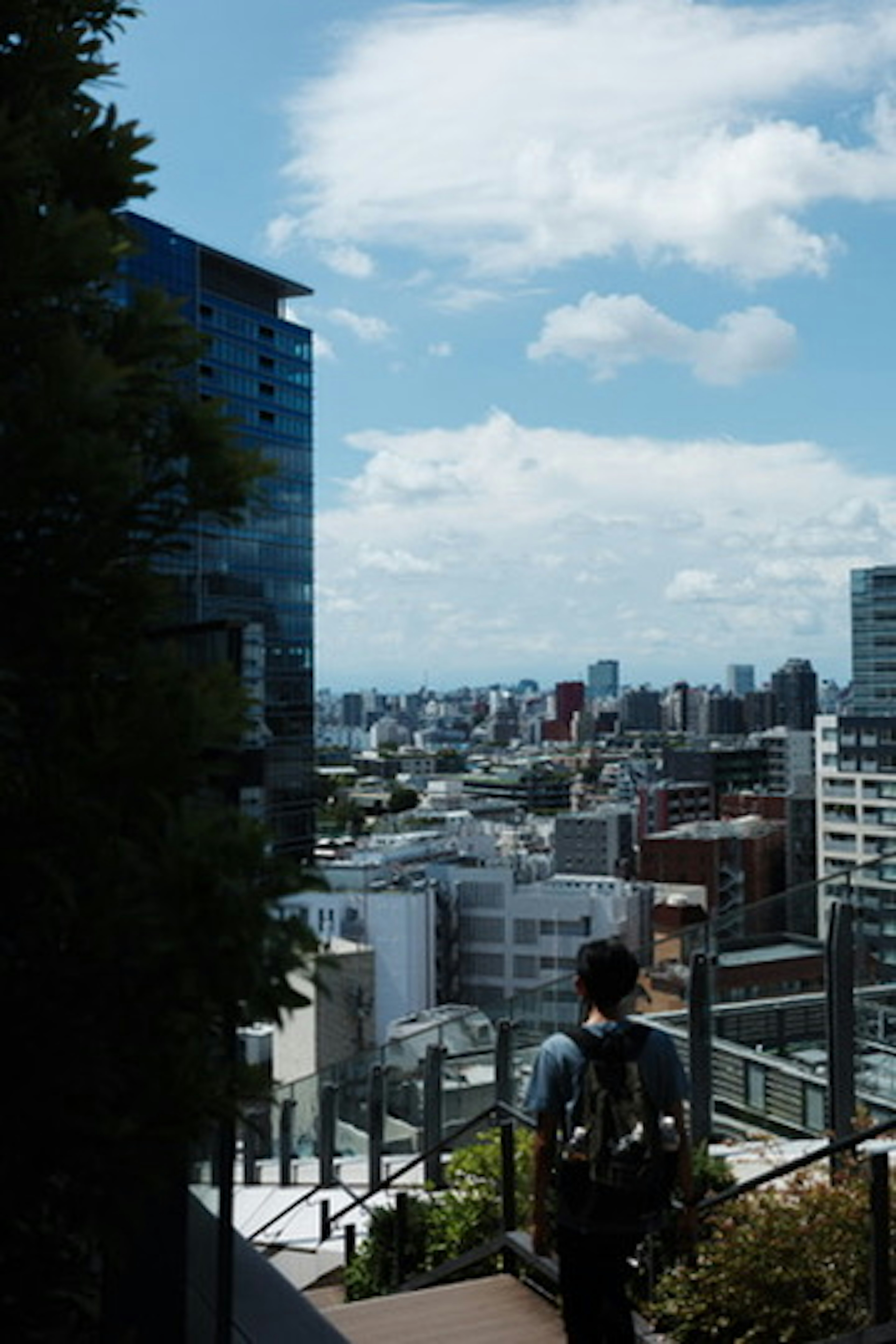 Uomo che osserva un paesaggio urbano con cielo blu