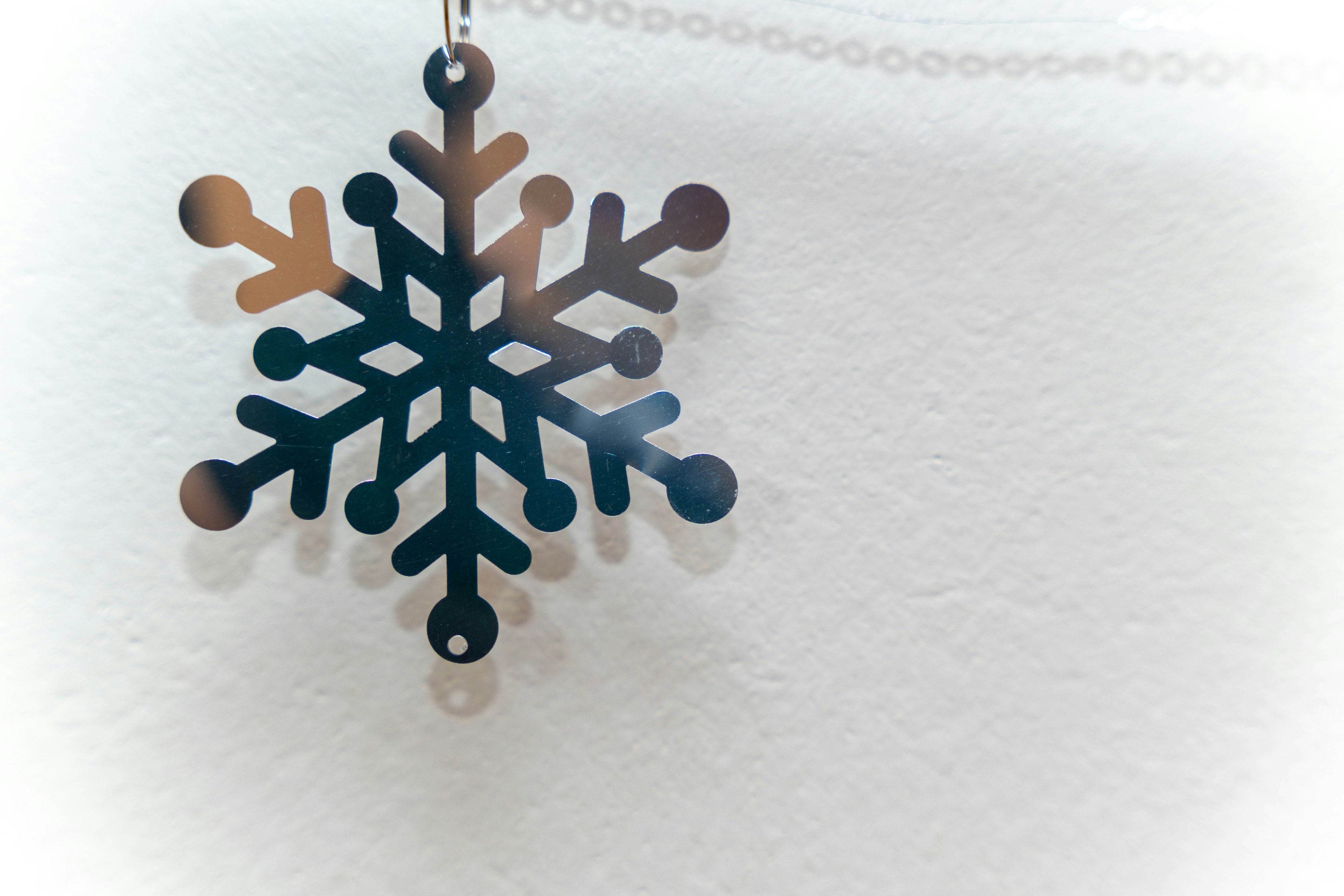 A blue and brown snowflake decoration hanging on a white wall