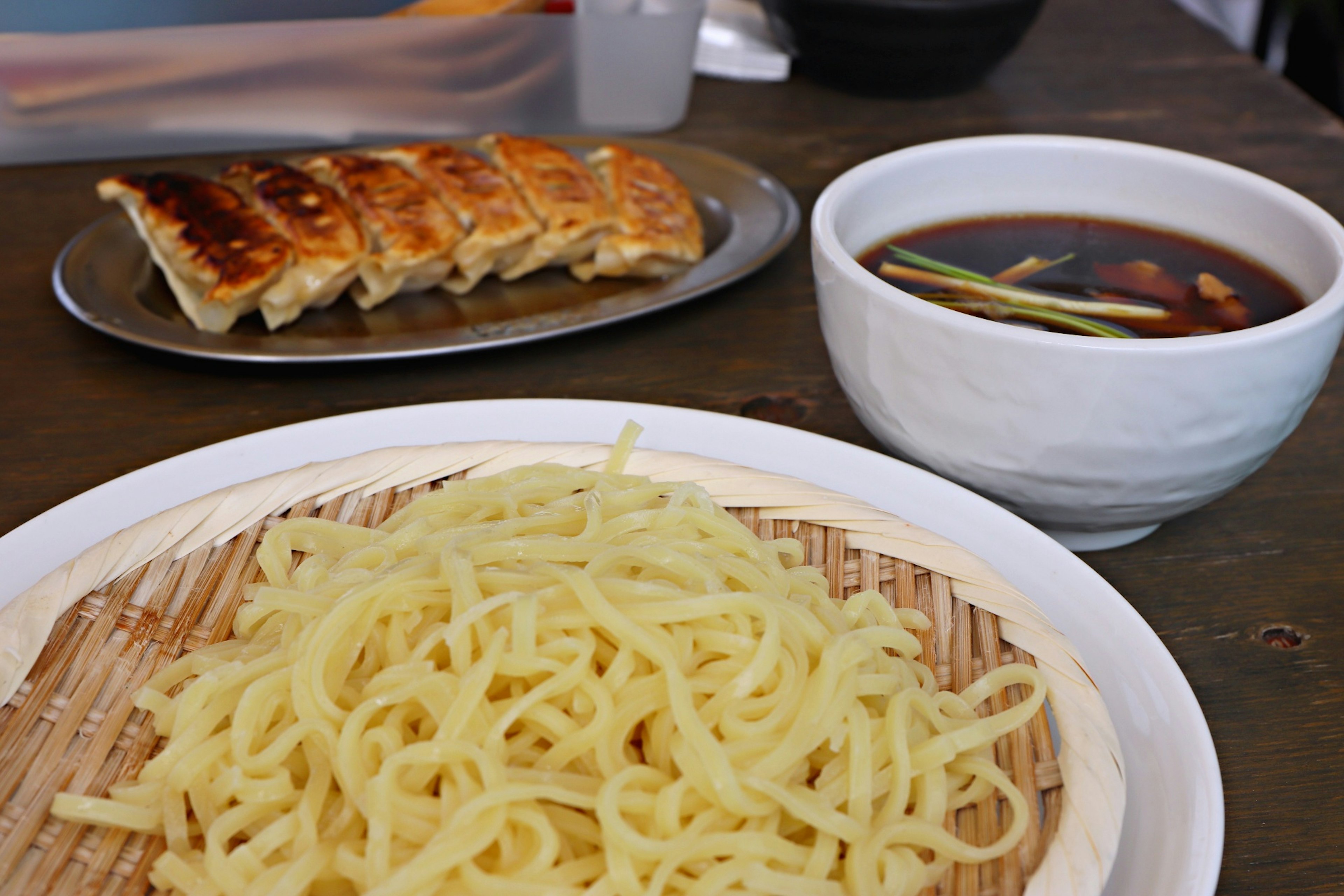 Piring mie tipis dengan gyoza dan saus celup