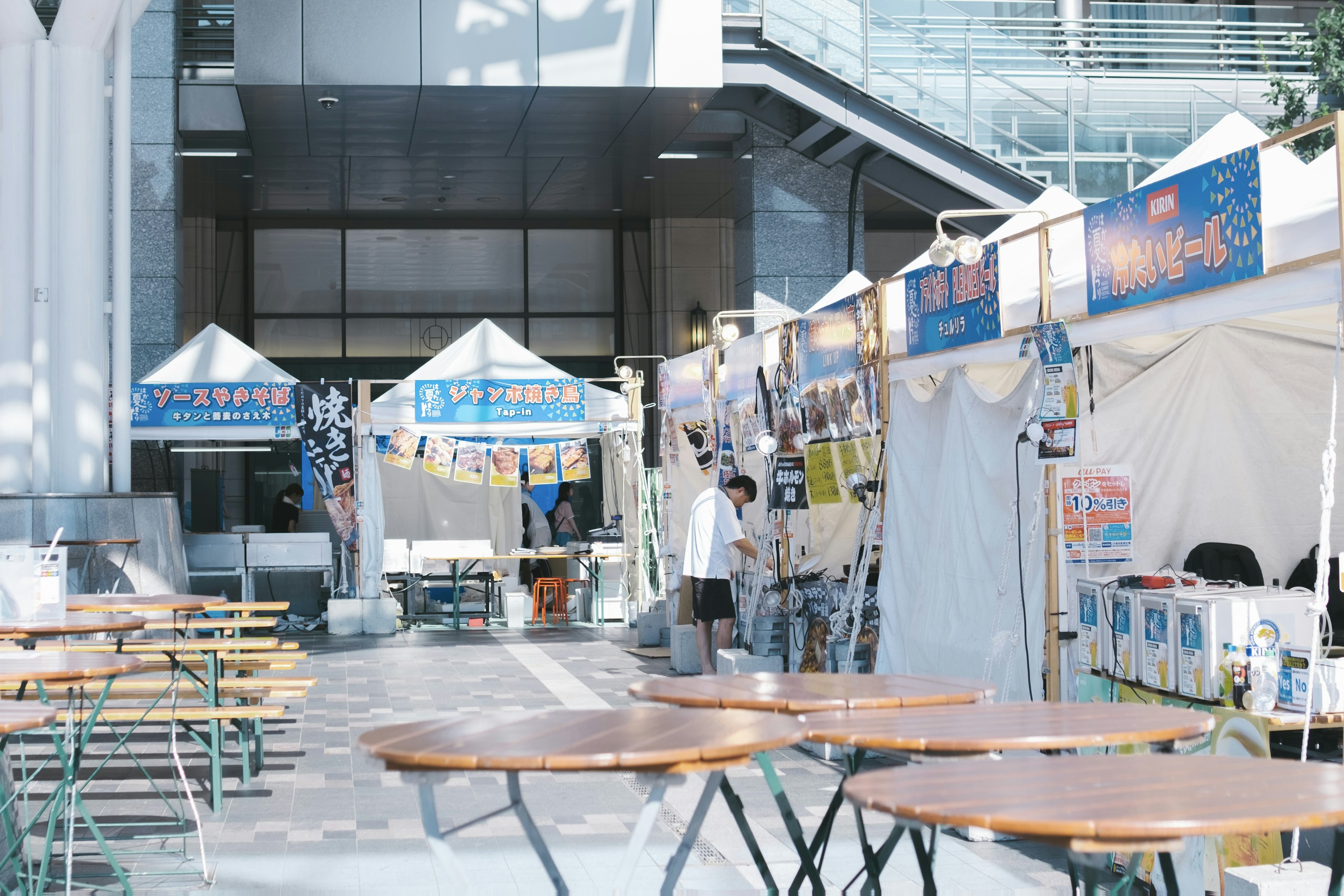 Escena de mercado al aire libre con puestos y mesas