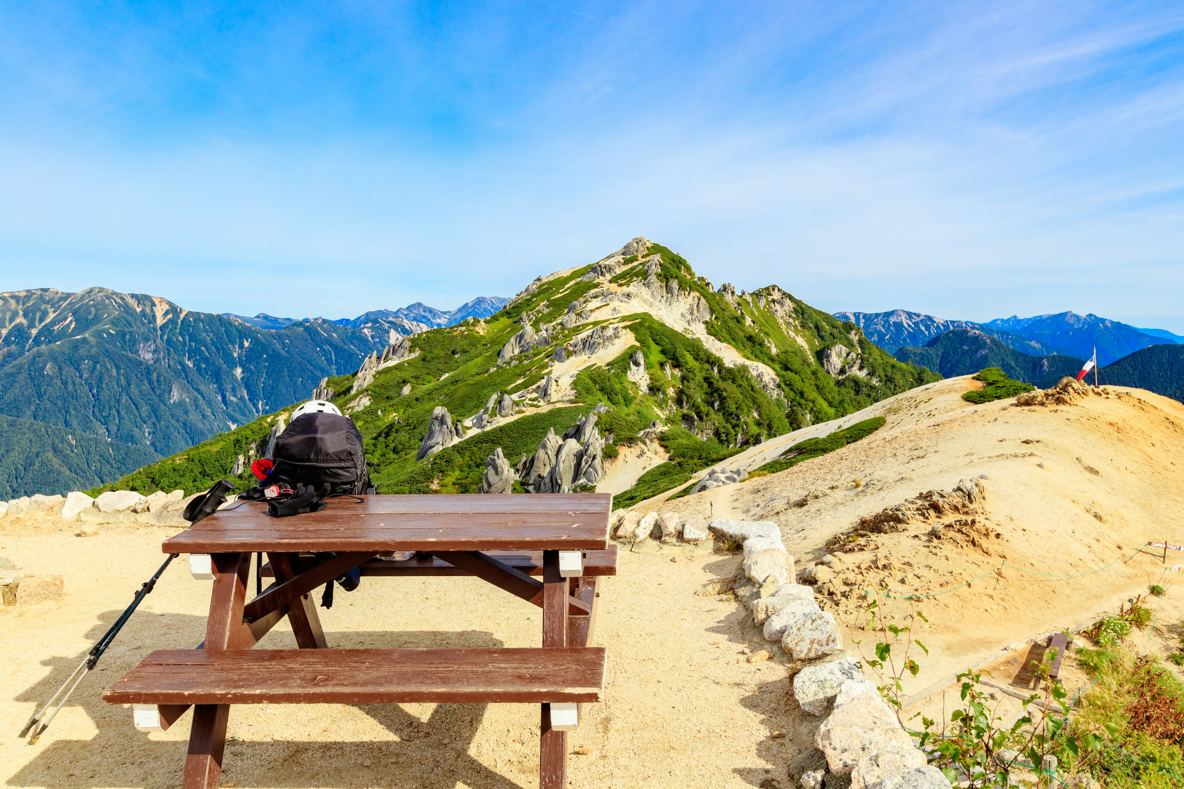 前景中有木桌和背包的风景如画的山景