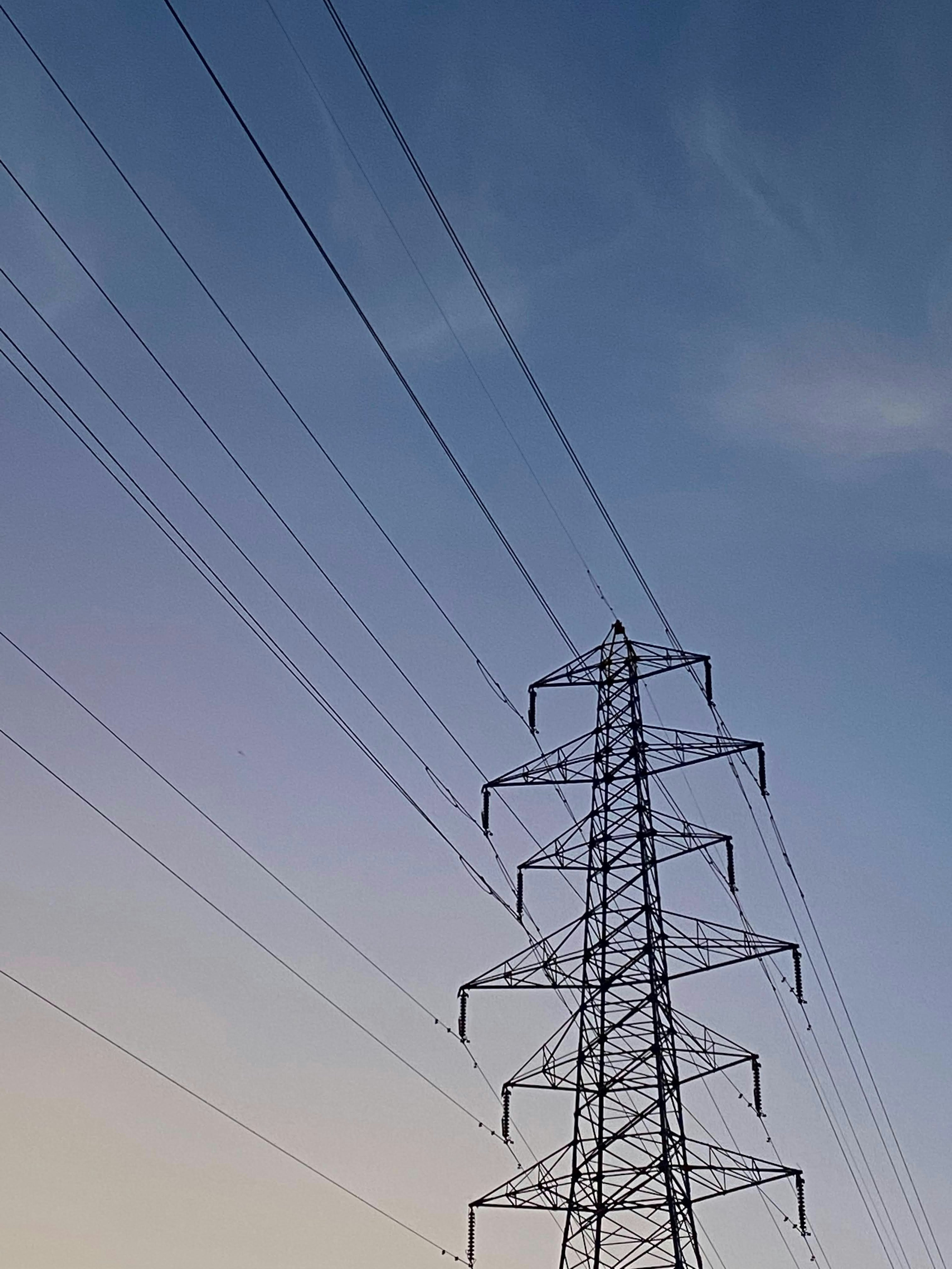 Power tower against a blue sky