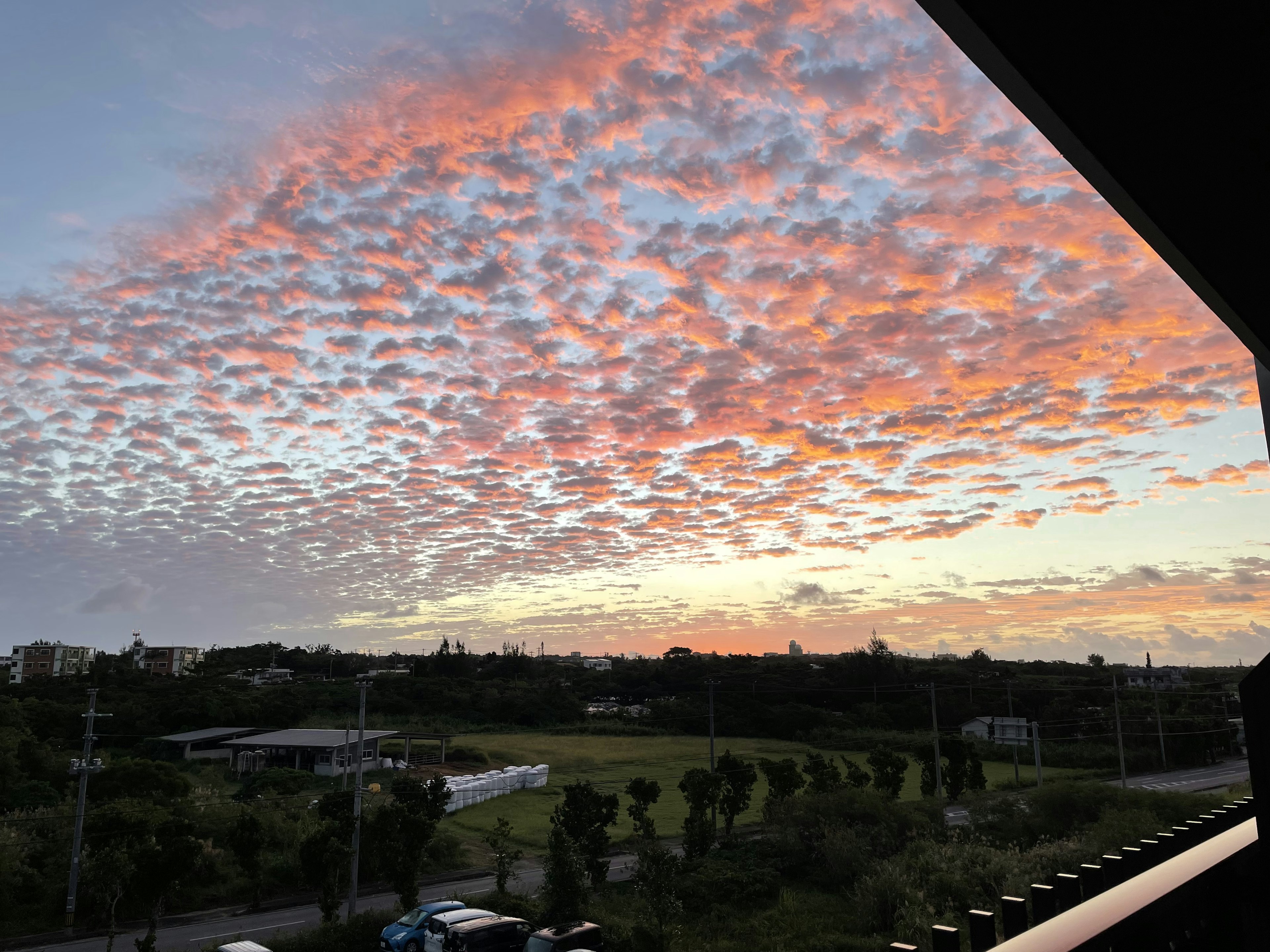 Langit senja berwarna dengan awan tersebar dan pemandangan sekitarnya